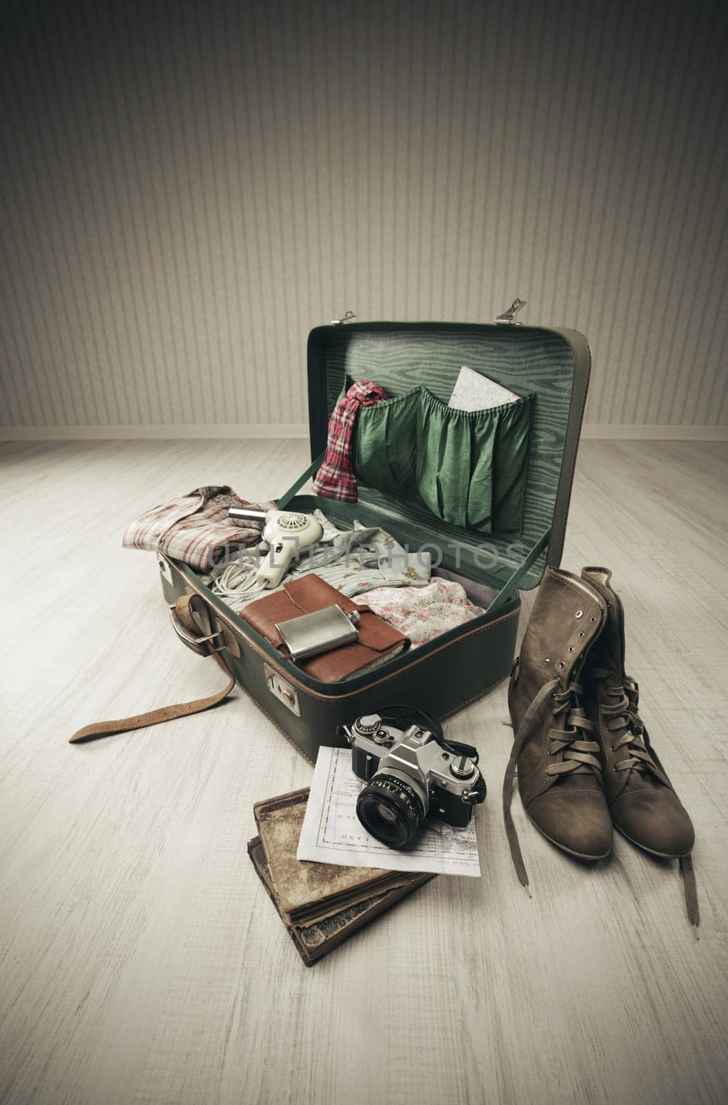 Vintage suitcase open on a wood floor in an empty room
