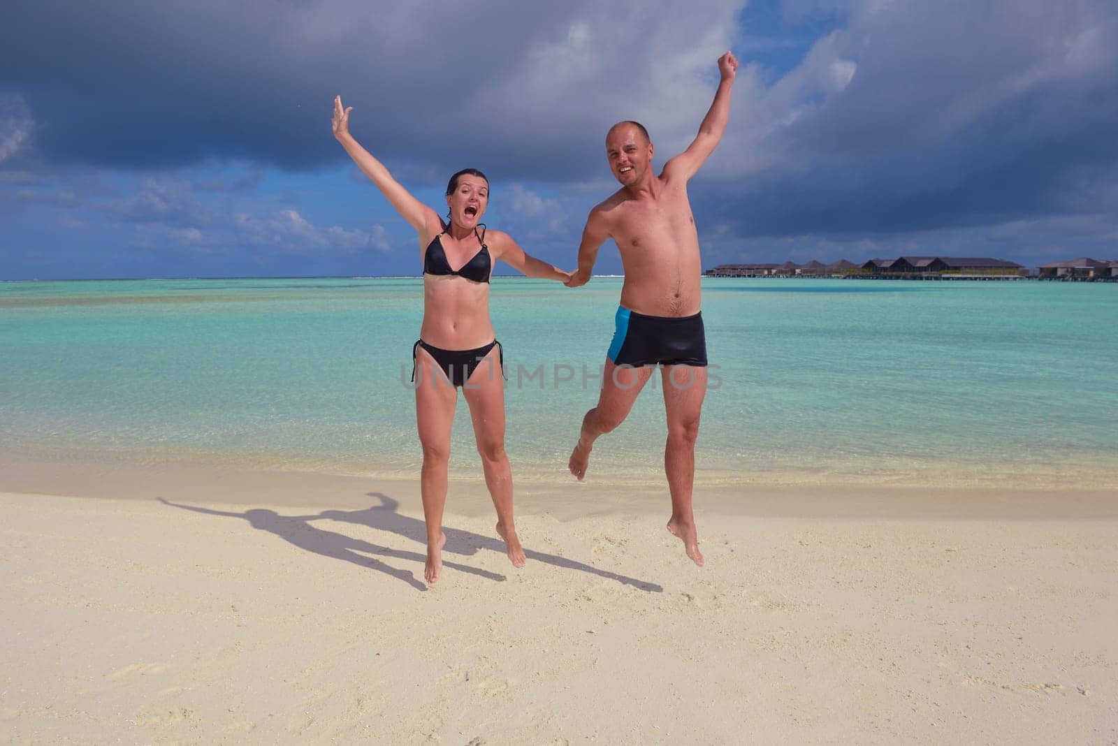 happy young couple have fun and relax at summer vacation on background maldives travel location and beautiful white sand beach