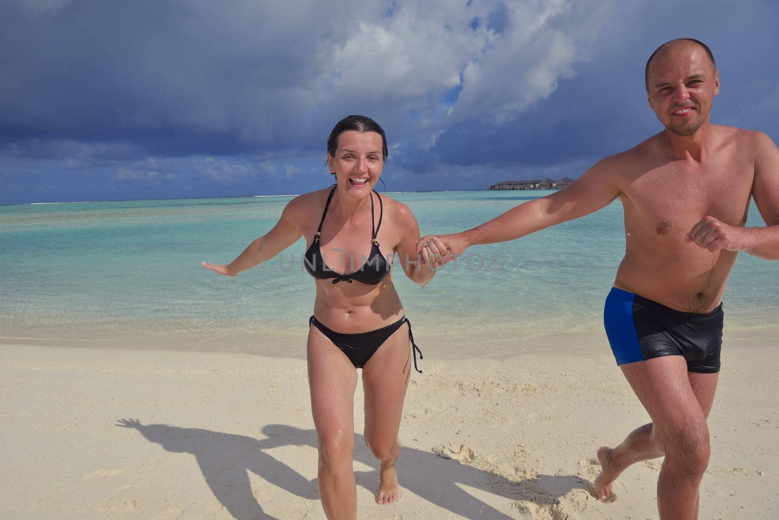 happy young couple have fun and relax at summer vacation on background maldives travel location and beautiful white sand beach