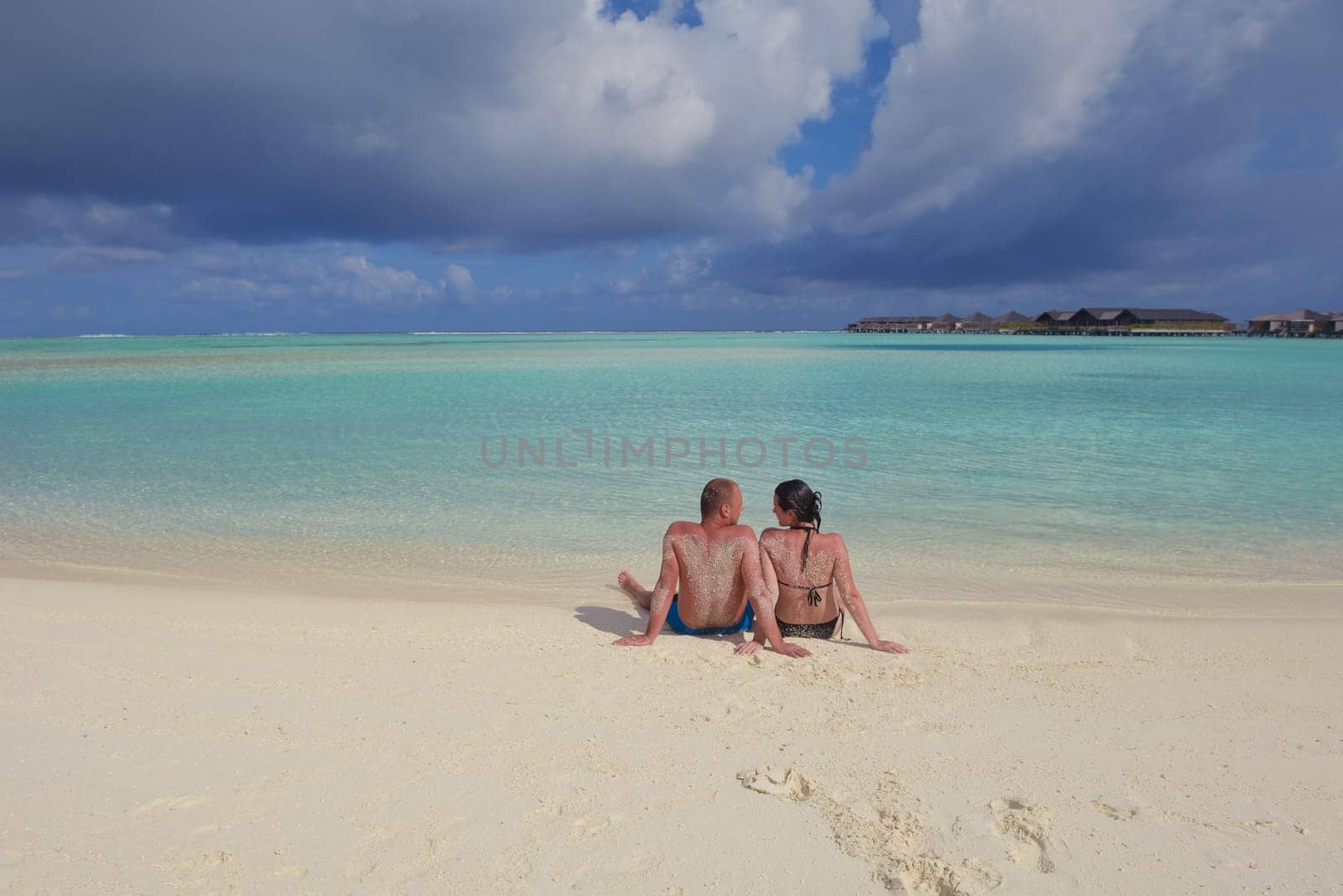 happy young couple have fun and relax at summer vacation on background maldives travel location and beautiful white sand beach
