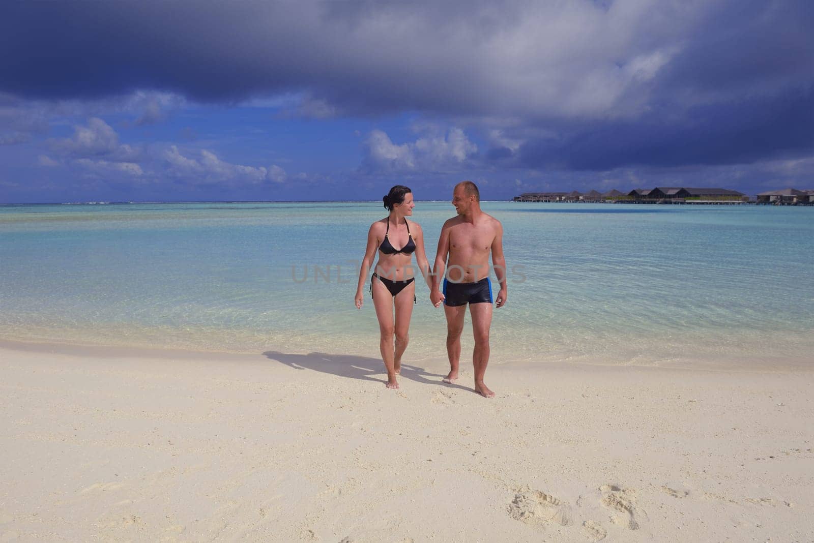 happy young couple have fun and relax at summer vacation on background maldives travel location and beautiful white sand beach