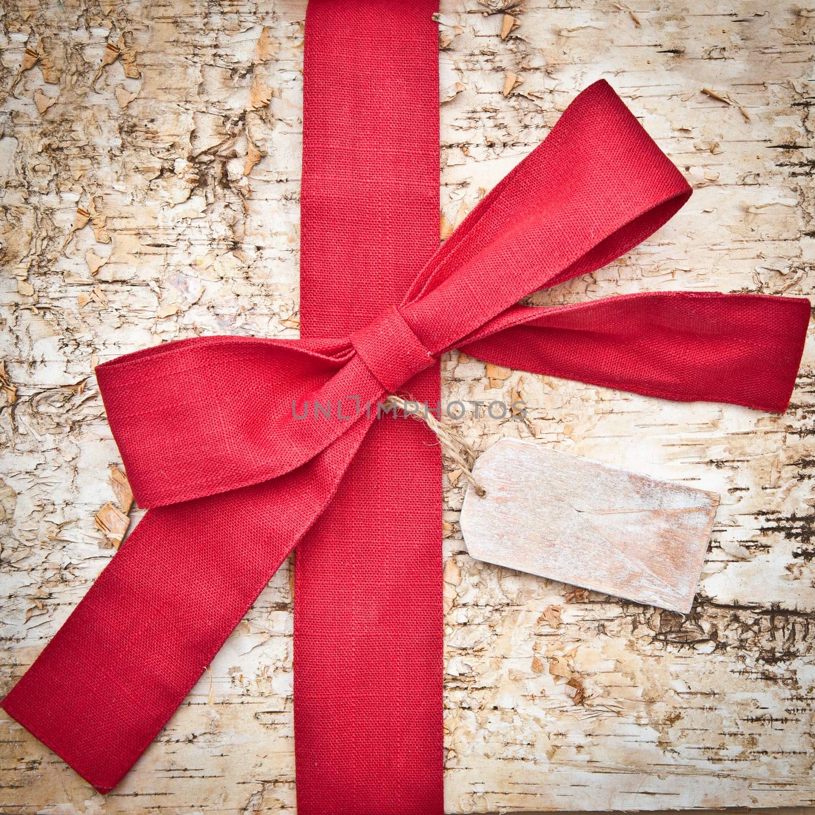 Birch bark background with large red ribbon