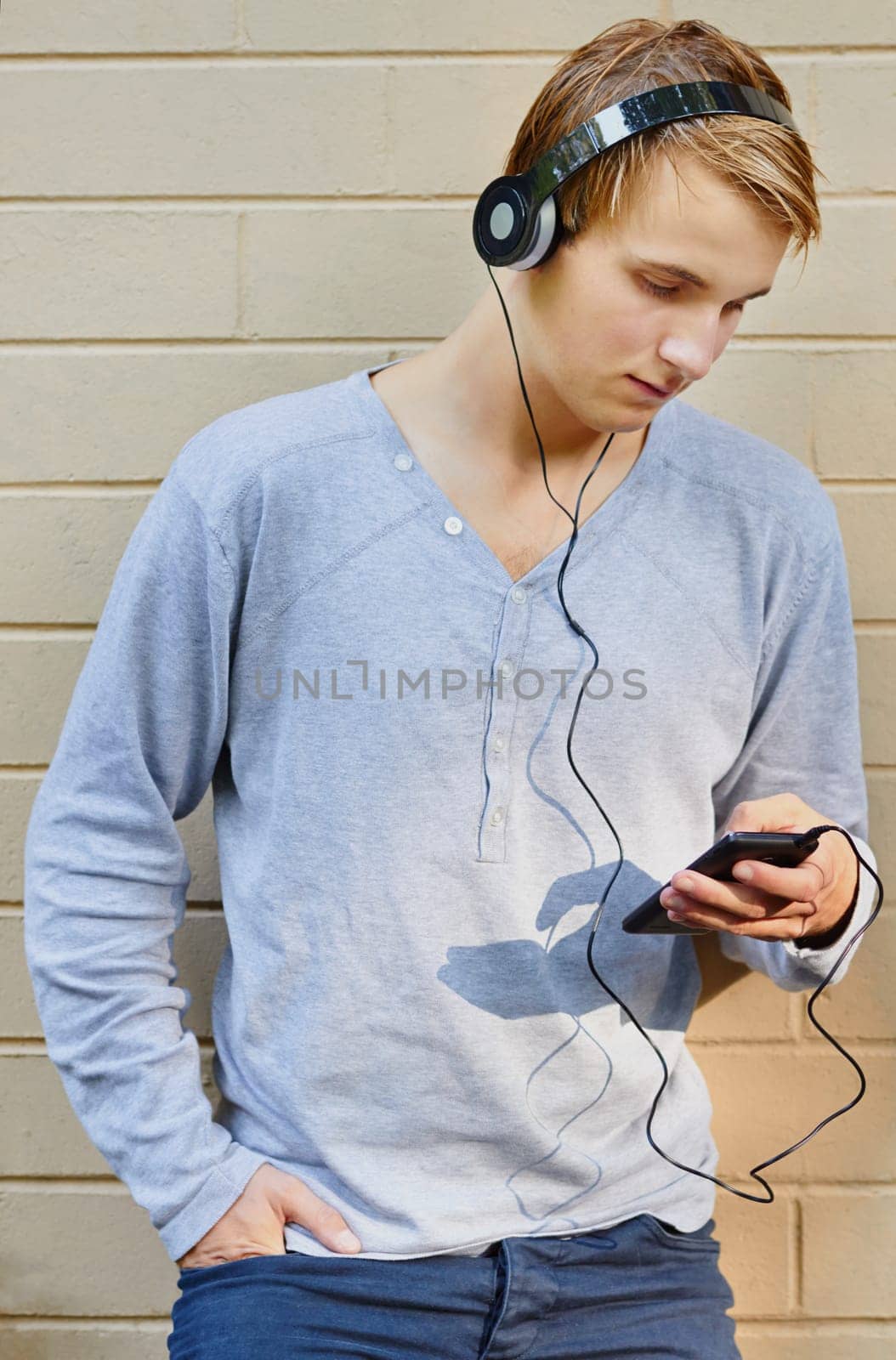 Young male scrolling through song list with sun highlighting mp3 player