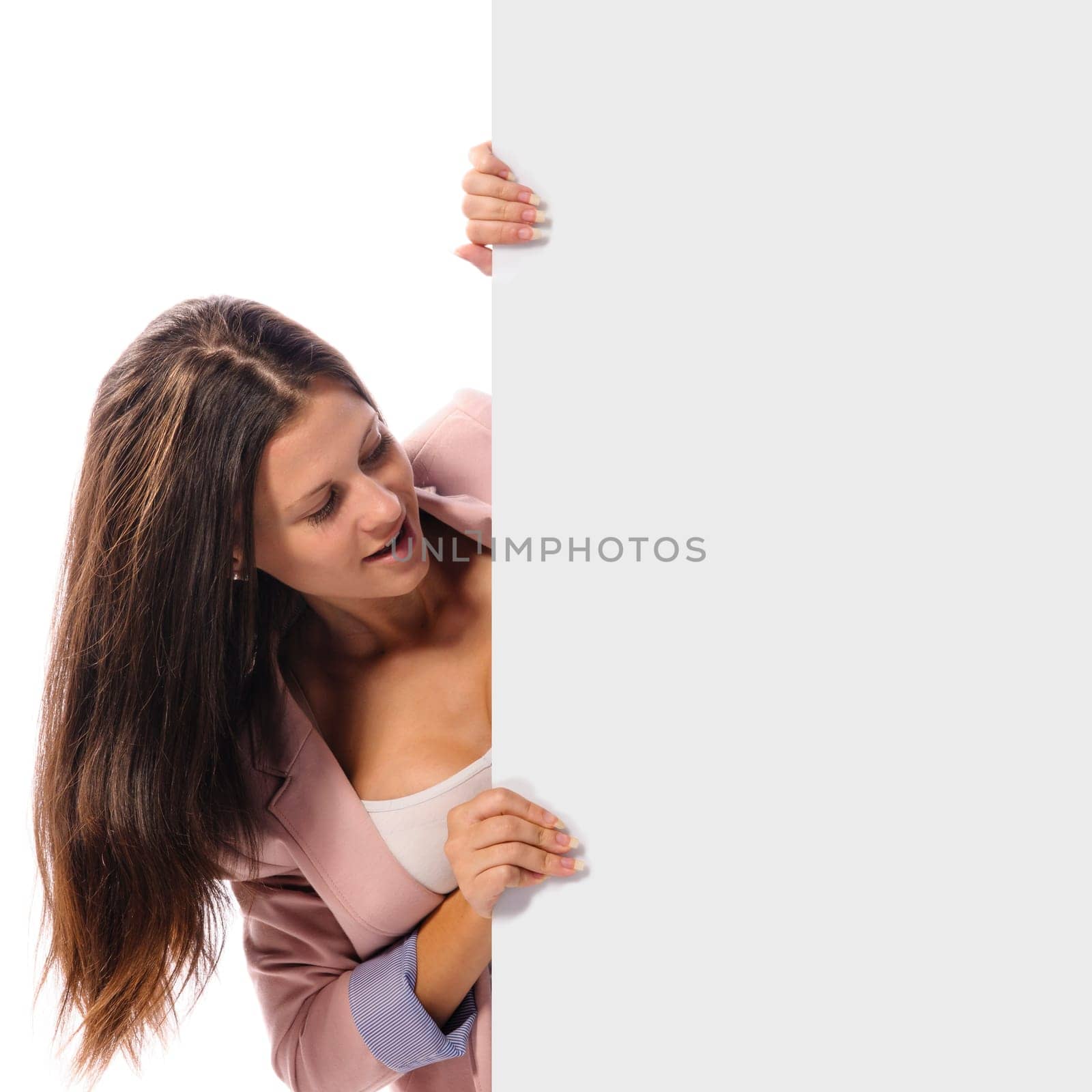 Cute young brunette woman holding a empty sign and smiling in the camera, isolated again white background.