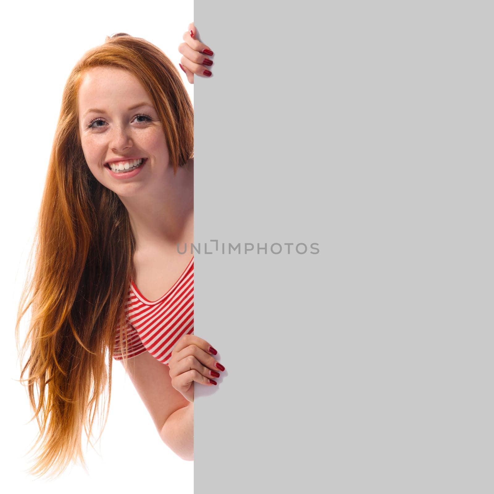 Cute young readhead woman holding a empty sign and laughing in the camera, isolated again white background.