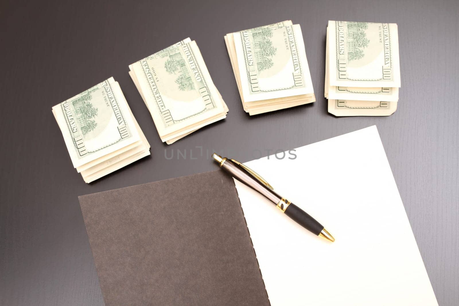 Lots of dollars with an open copybook.