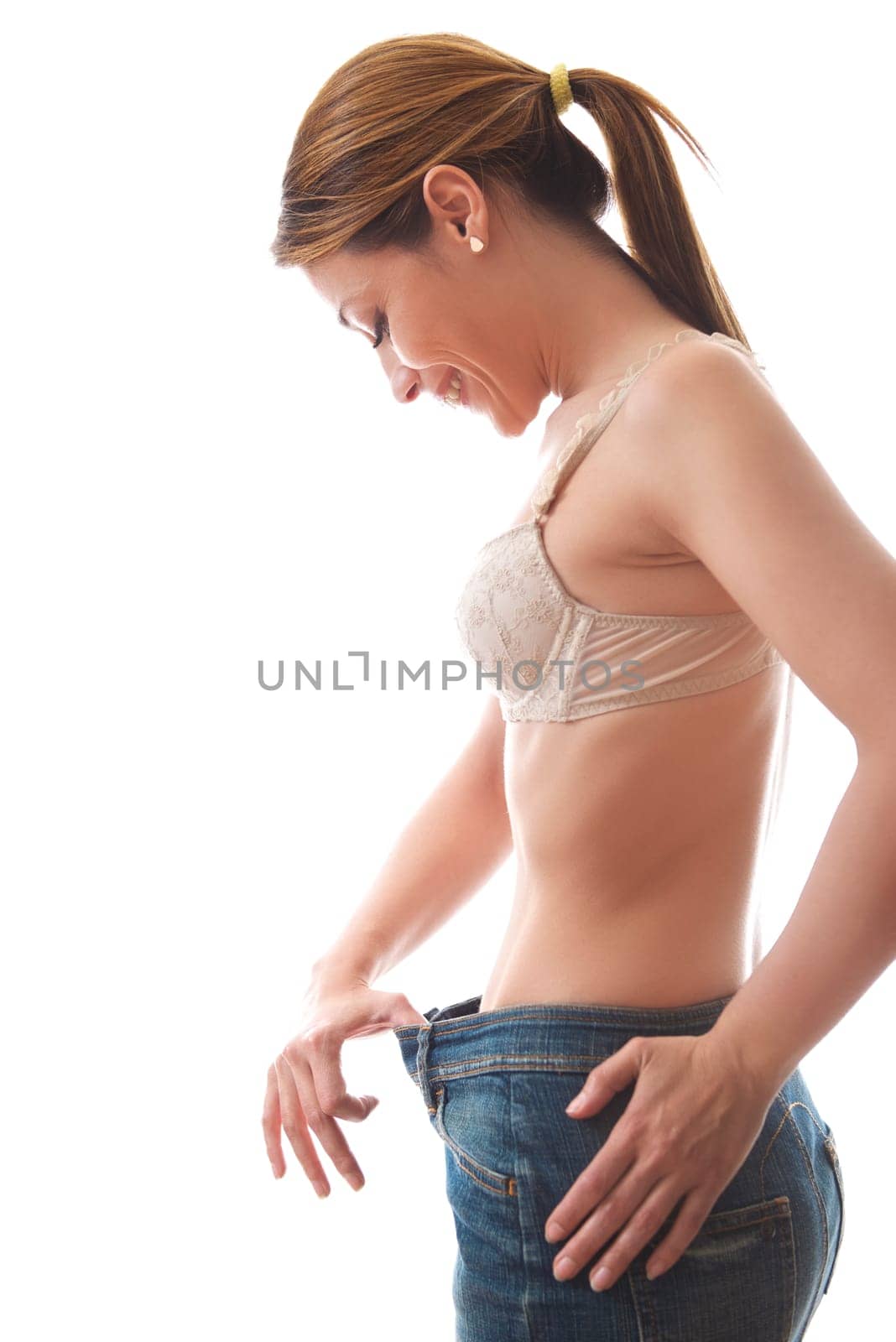 young woman dieting and contemplating weight loss wearing jeans gown on white background