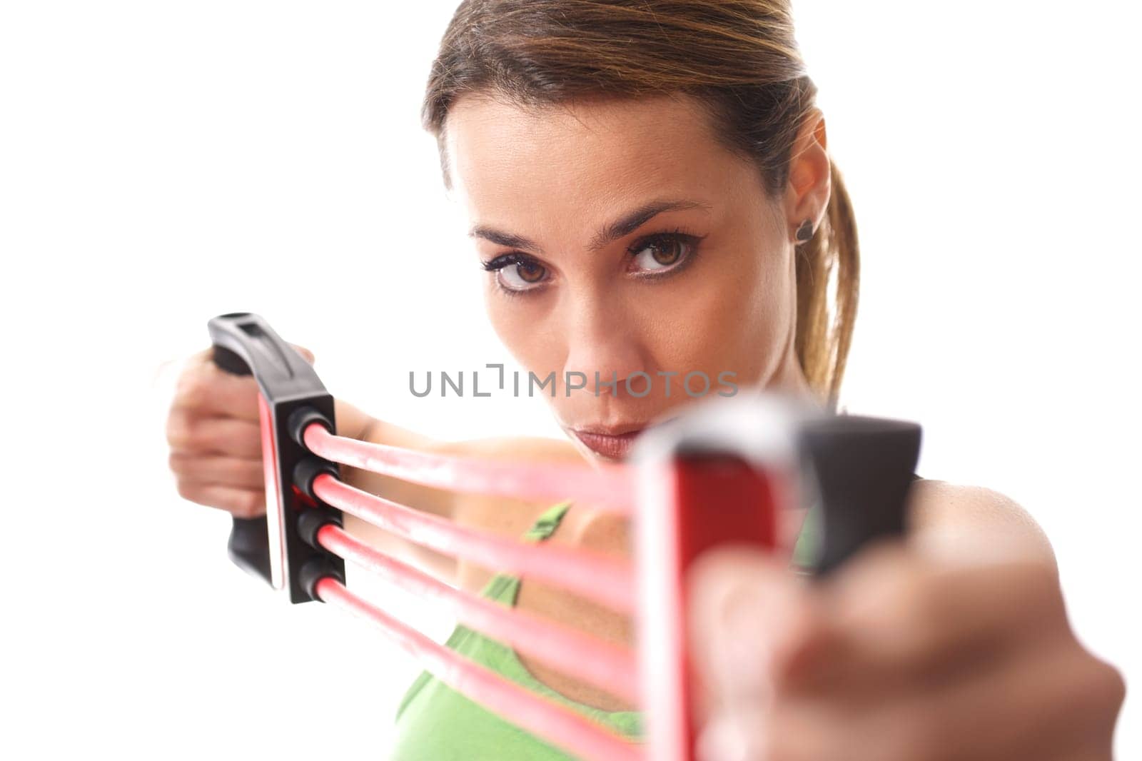 mid adult woman doing fitness exercise and training muscles with rubber band on white background