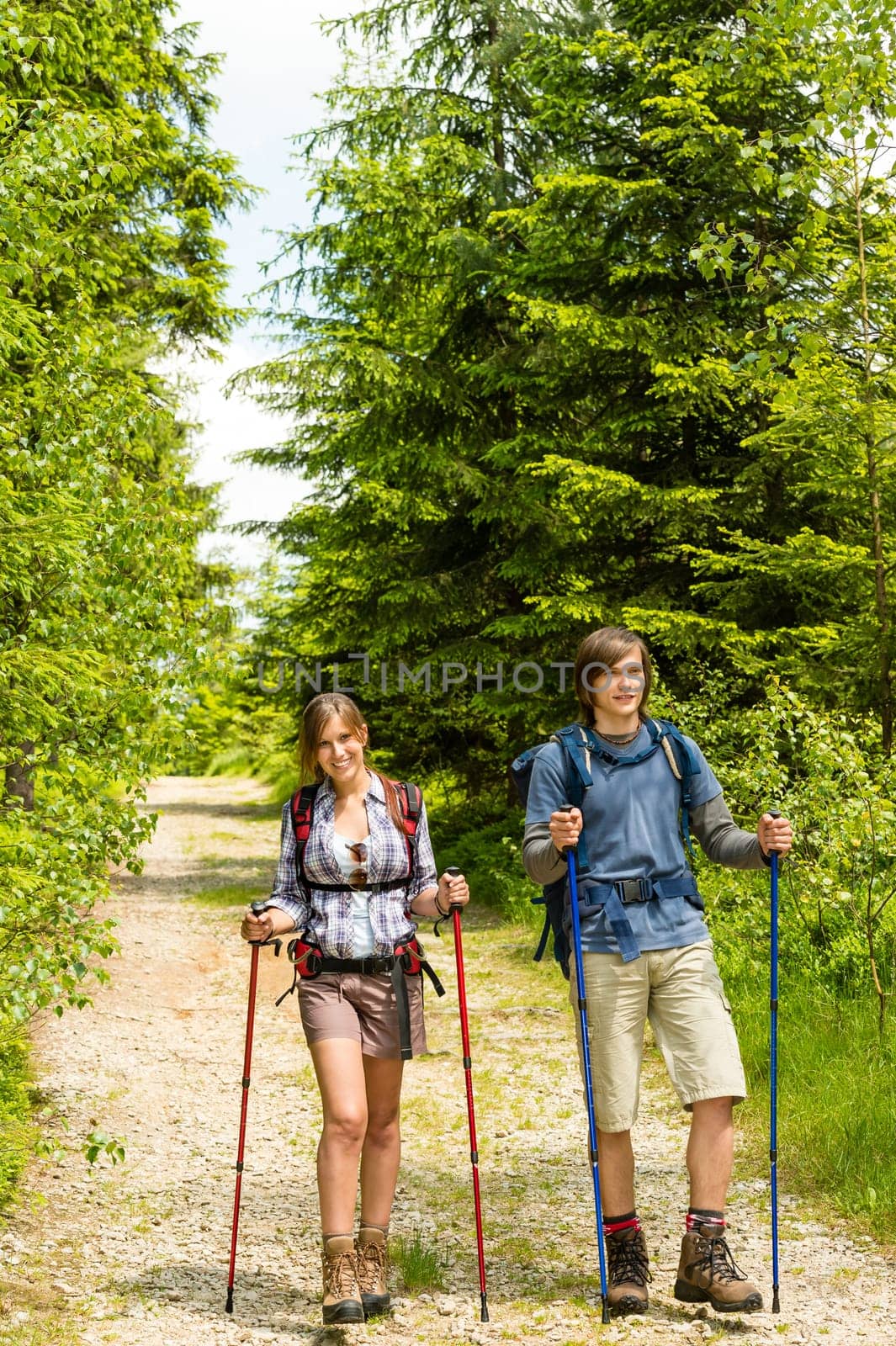 Young caucasian teenagers hiking in forest countryside