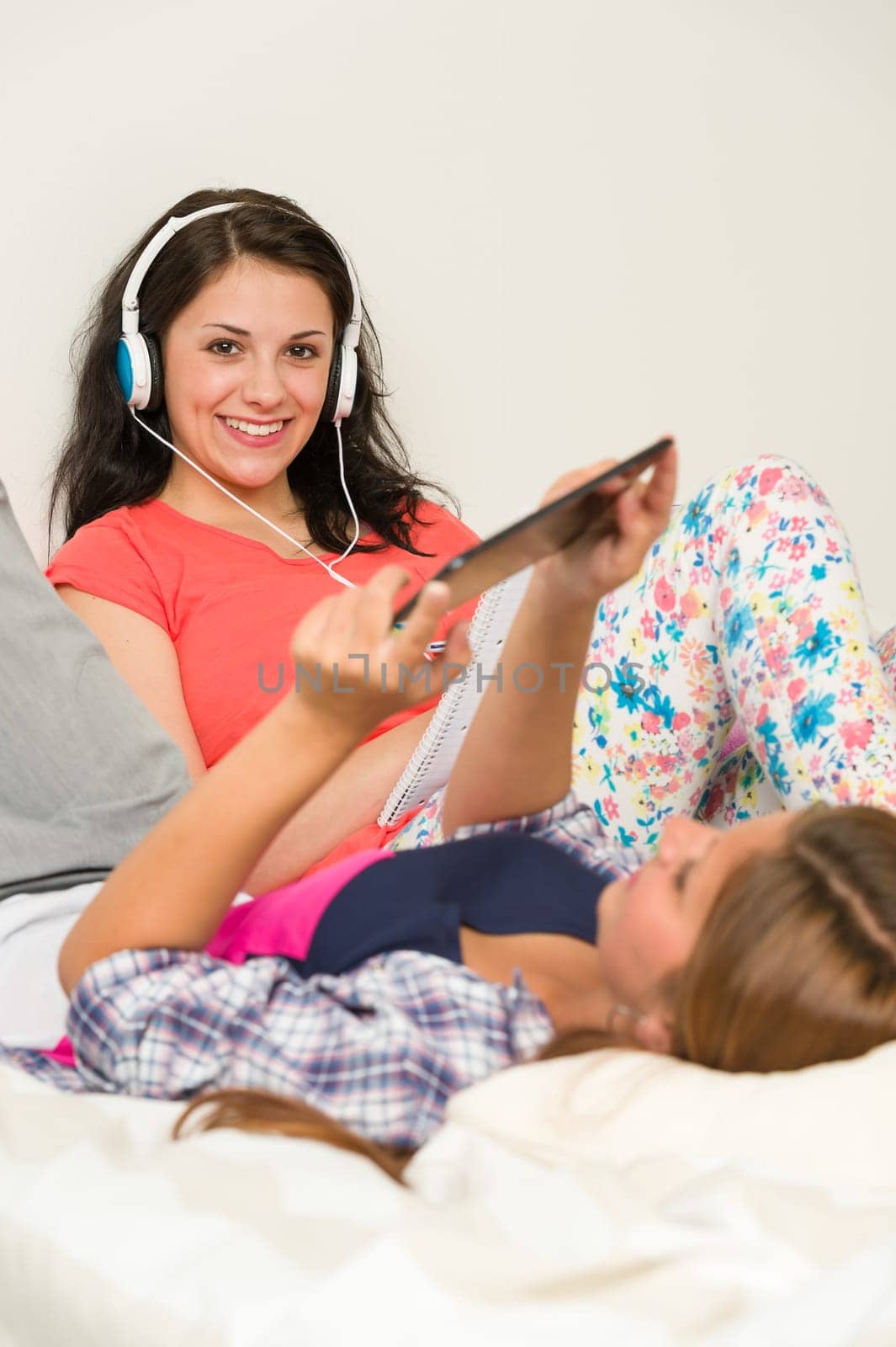 Best friends lounging and reading on bed