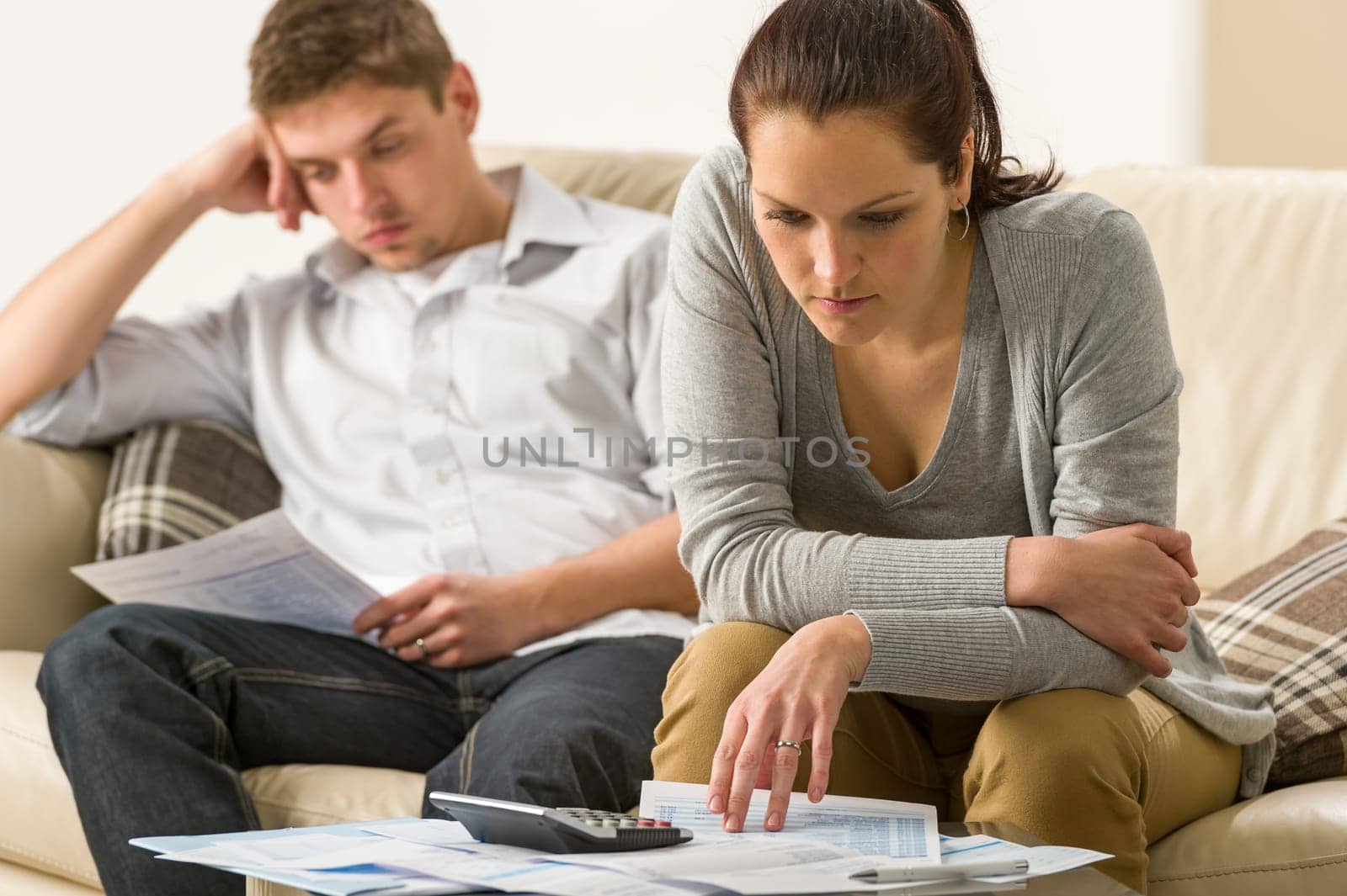 Annoyed couple calculating their finances during recession