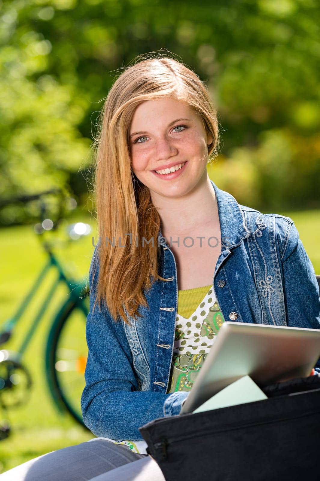 Student girl studying outside in the sunshine using tablet