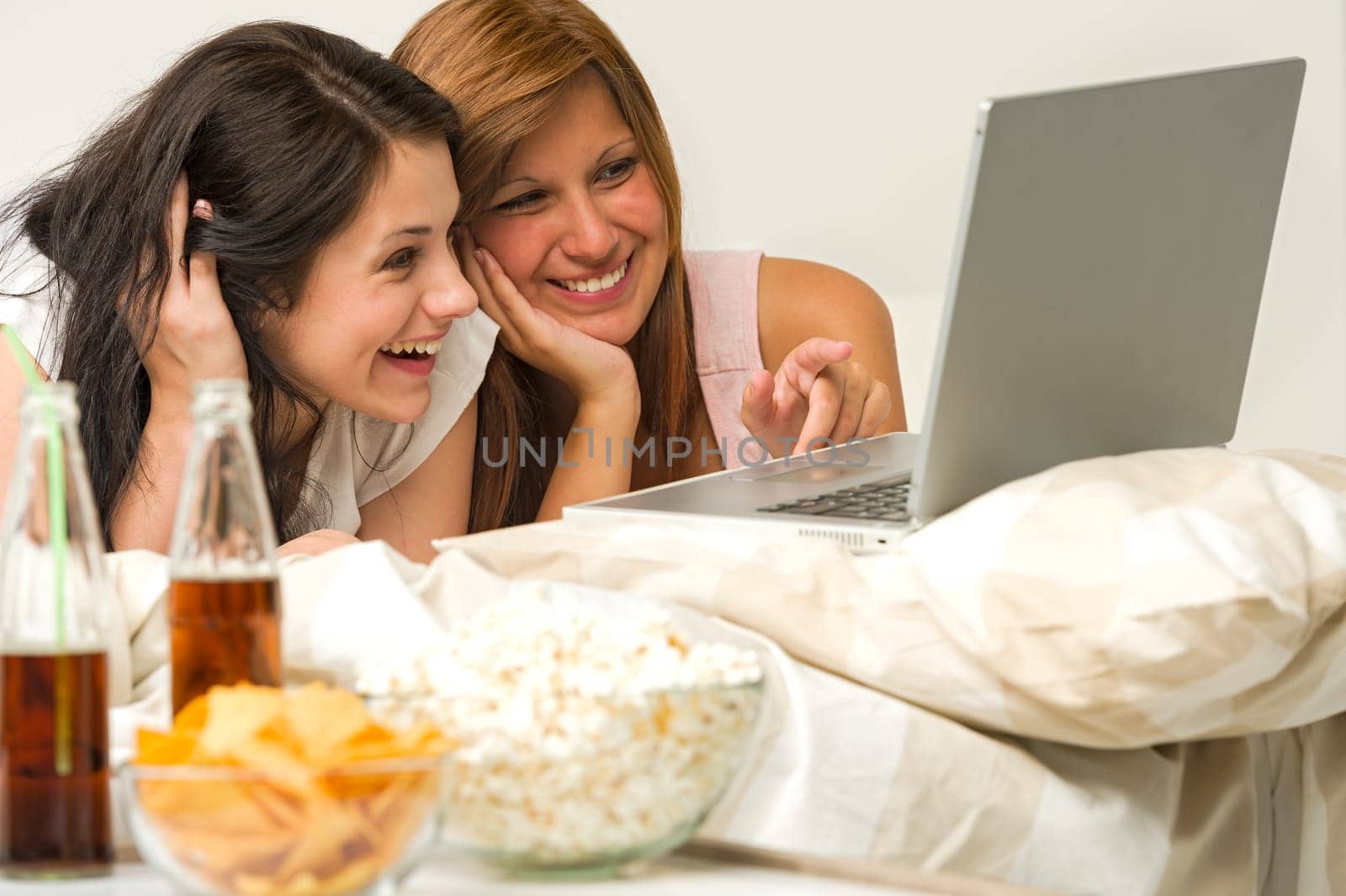 Teenagers friends enjoy movie night watching laptop and laughing