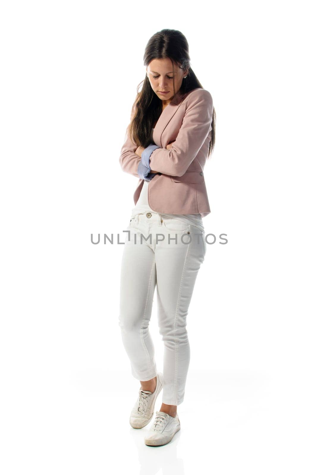 Young woman standing with folded arms sad and isolated against white background.