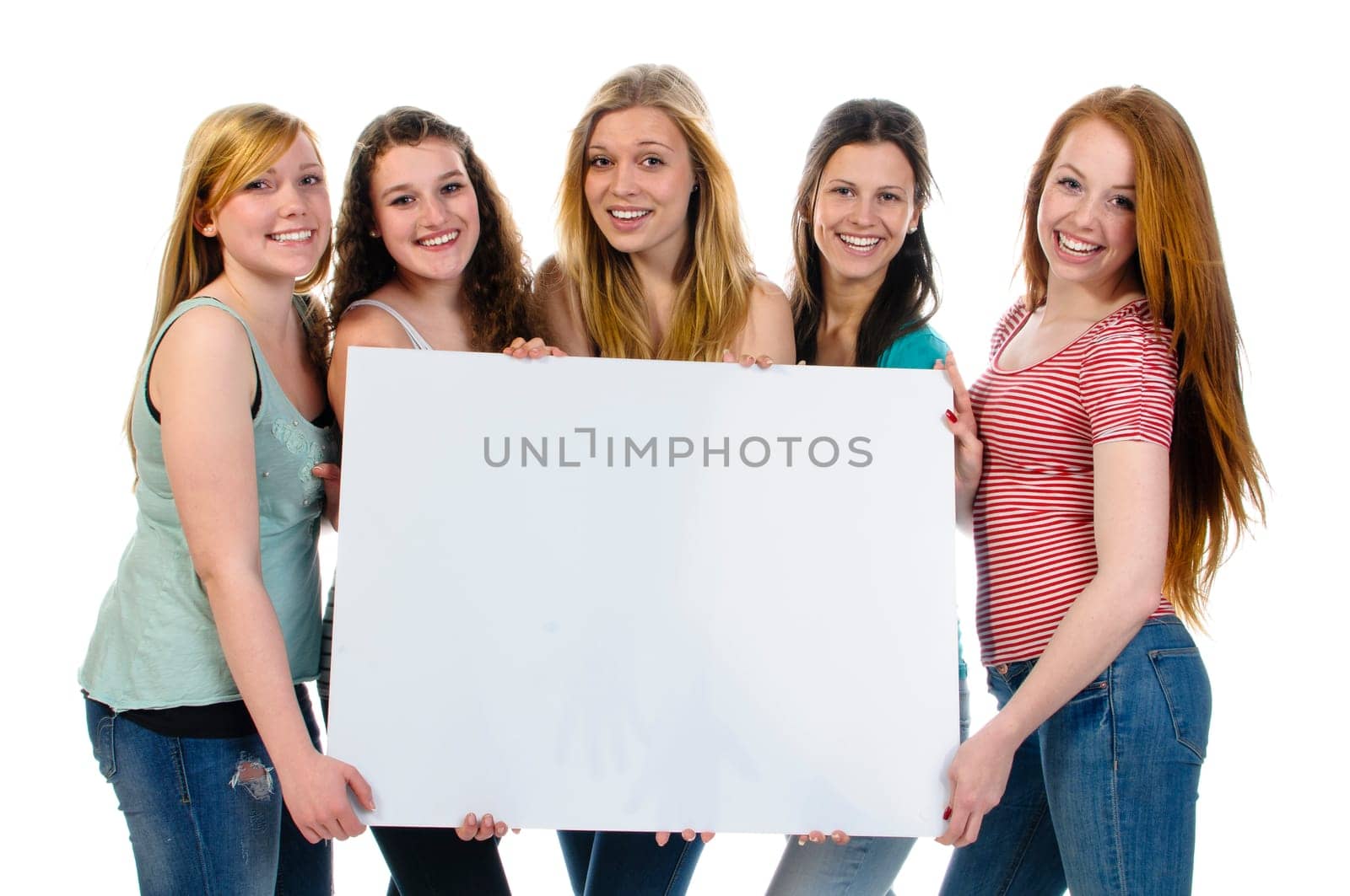 Five cute teenage girls holding a billboard add and laughing at the camera, isolated over a white background.