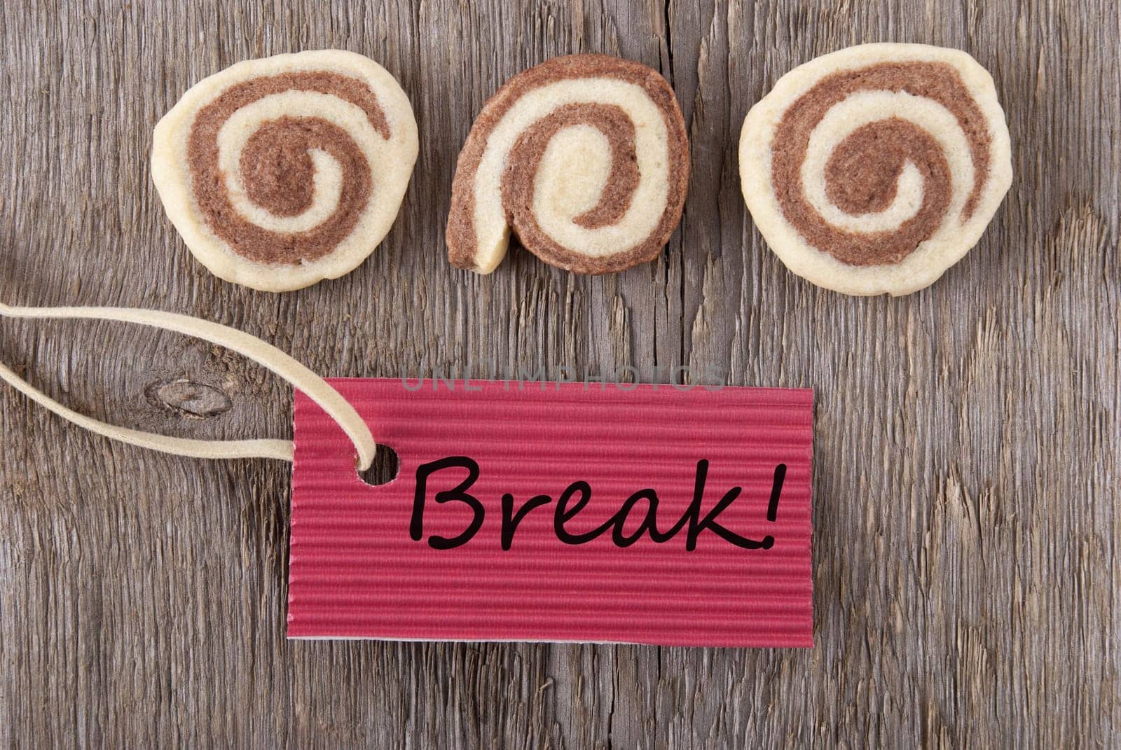 a red label with break on it on a wooden background with three cookies