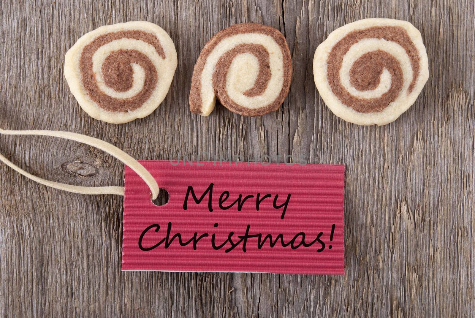 merry christmas written on a red marker tag with some christmas cookies