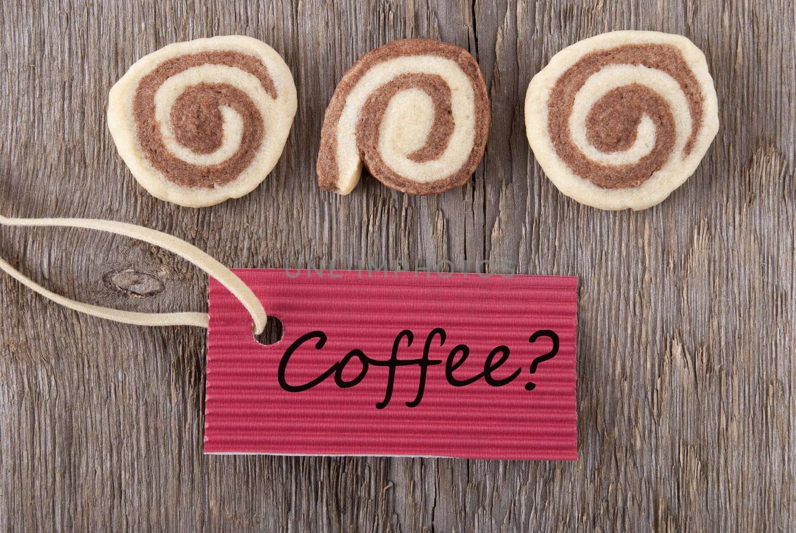 a red label with coffee on it and some cookies on a wooden background