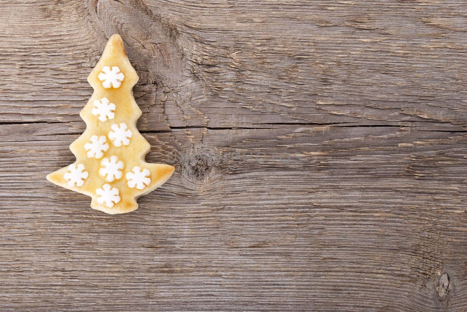 a christmas tree cookie on a wooden background with copyspace