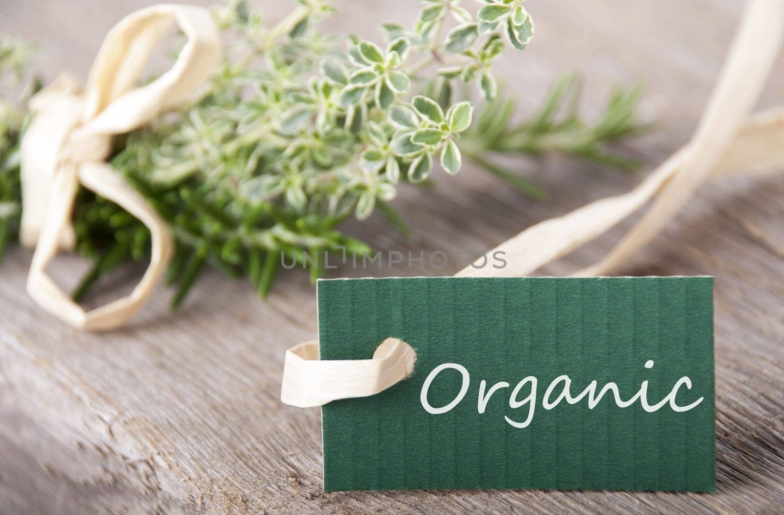 green label with organic on it and with fresh herbs in the background on wood