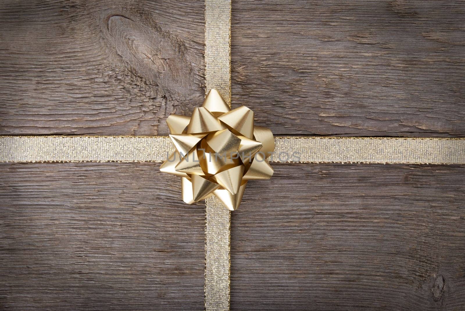 a golden bow in the middle of a golden ribbon on wood and framed, background
