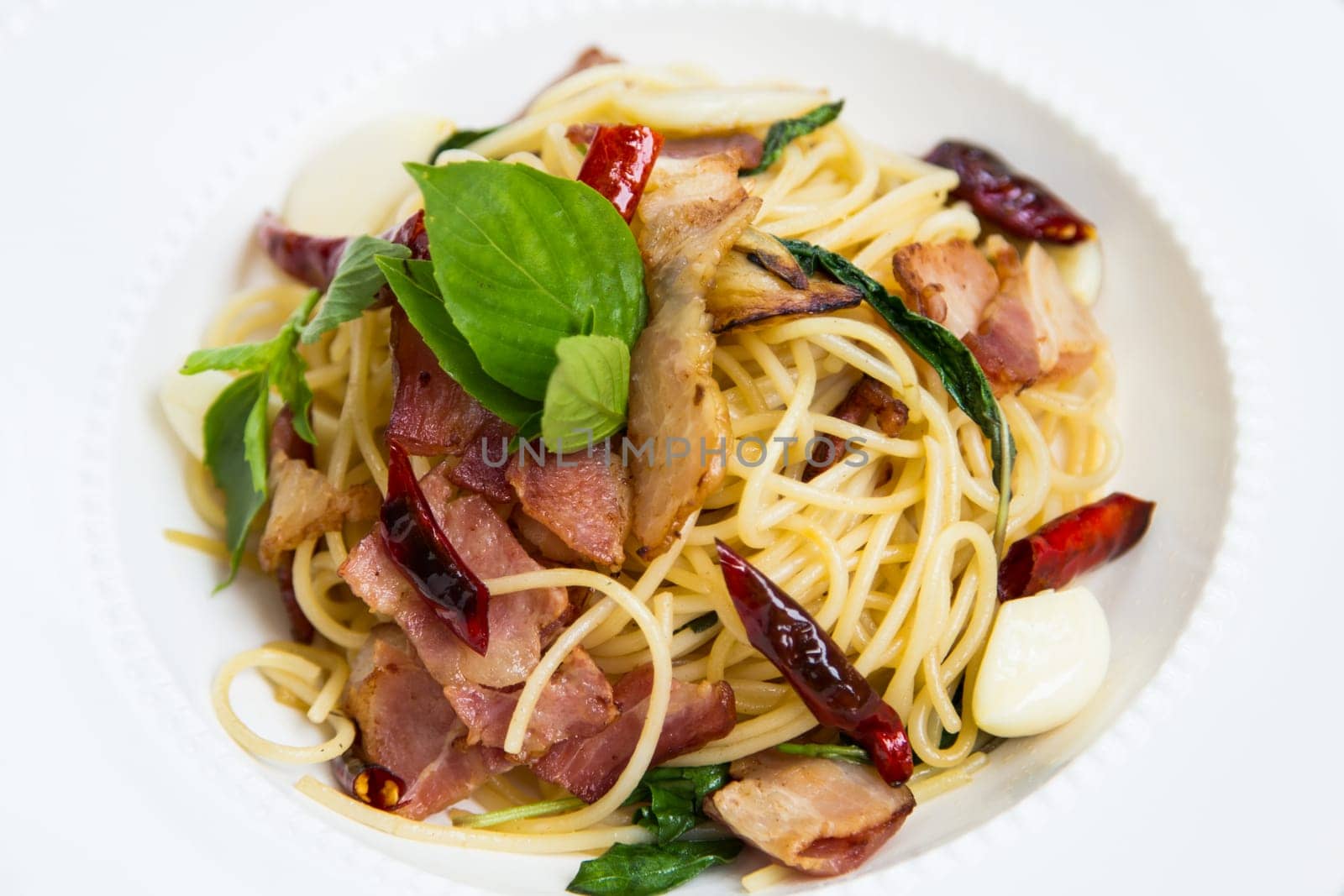 spaghetti with bacon in the pan and herb