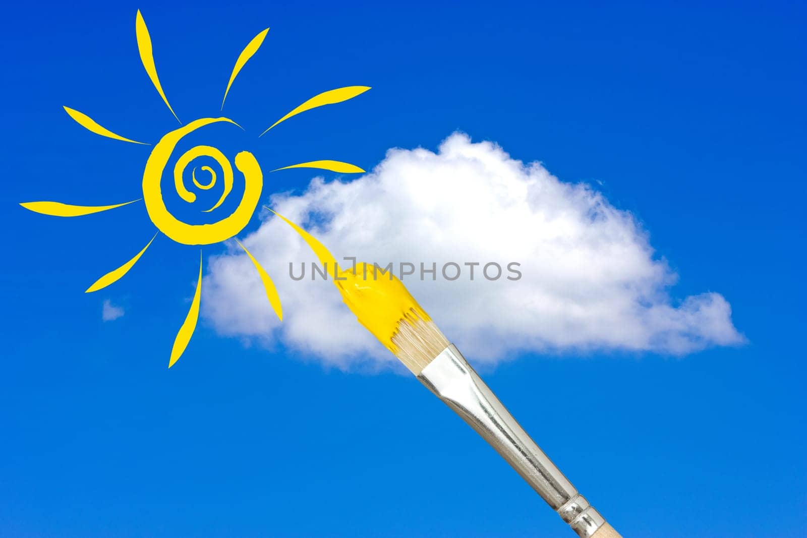 Paintbrush painting the yellow sun in a blue sky
