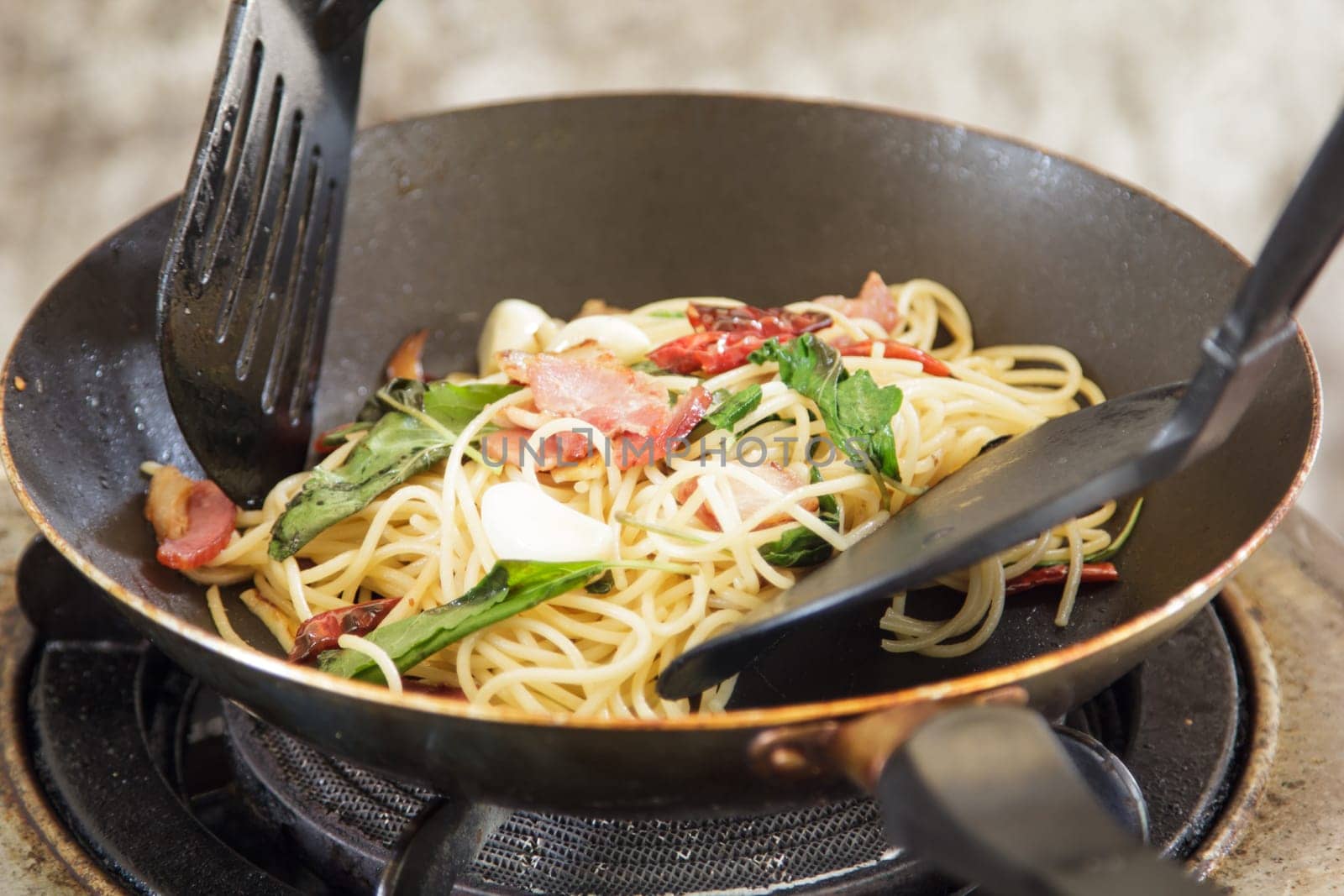 spaghetti with bacon in the pan and herb