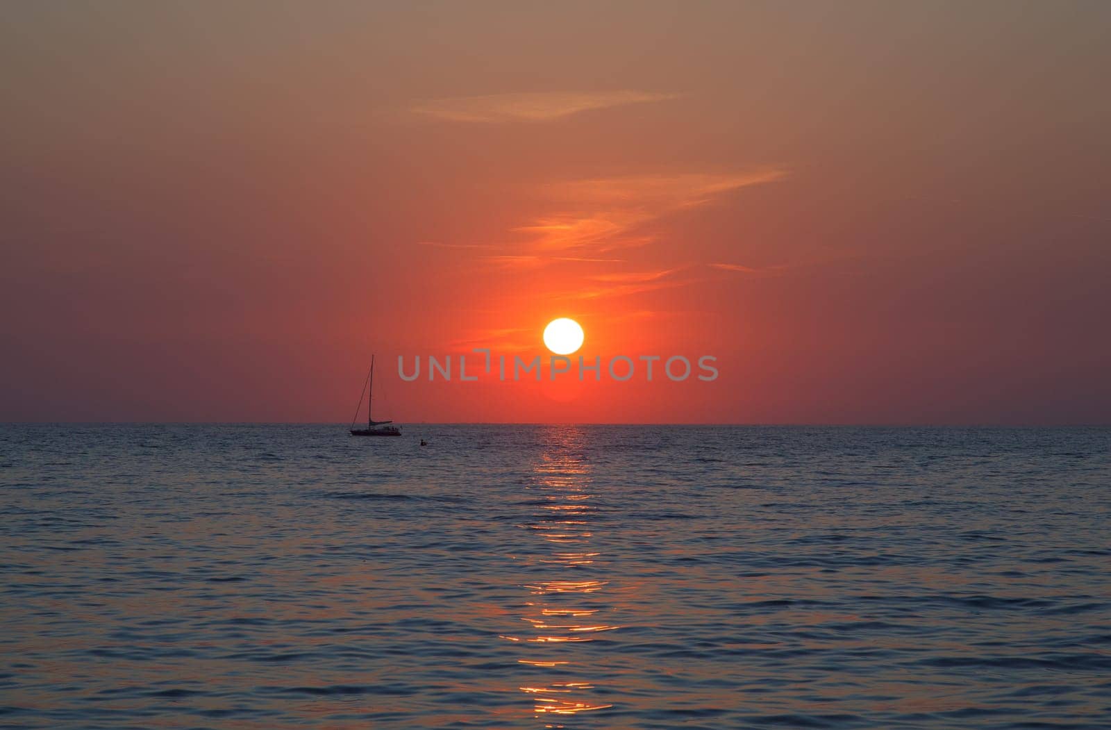 Sunset at sea with a sailboat in Trieste