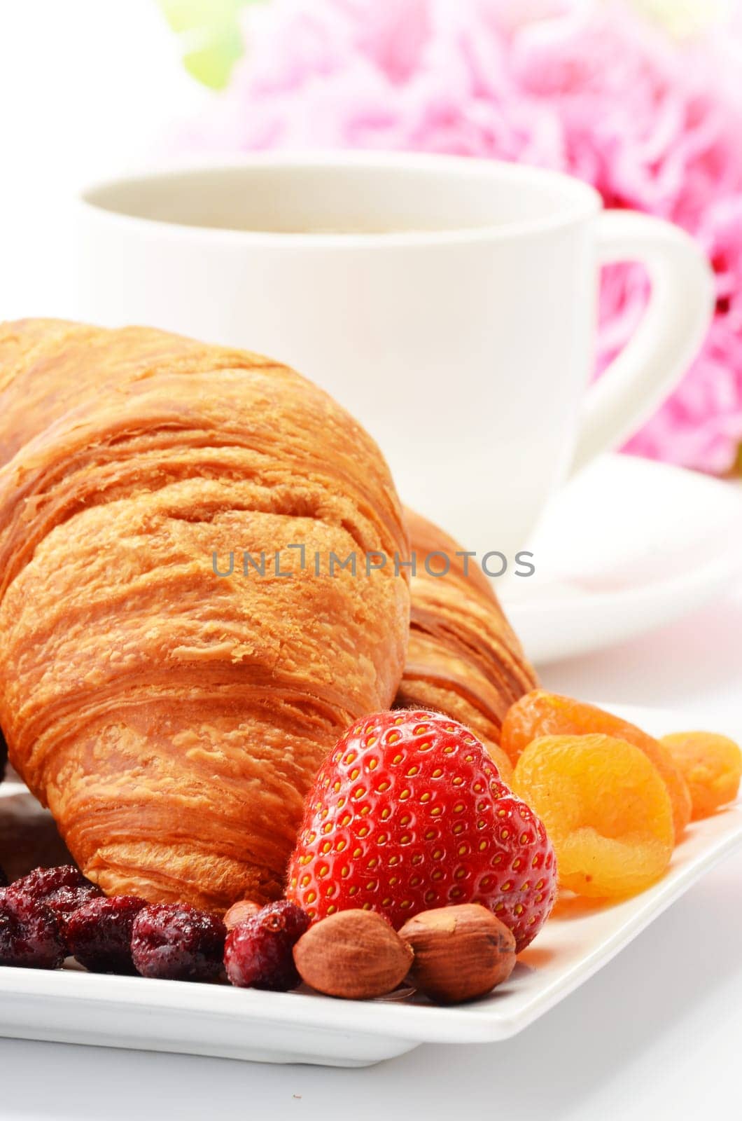 Breakfast with croissants, cup of coffee and fruits