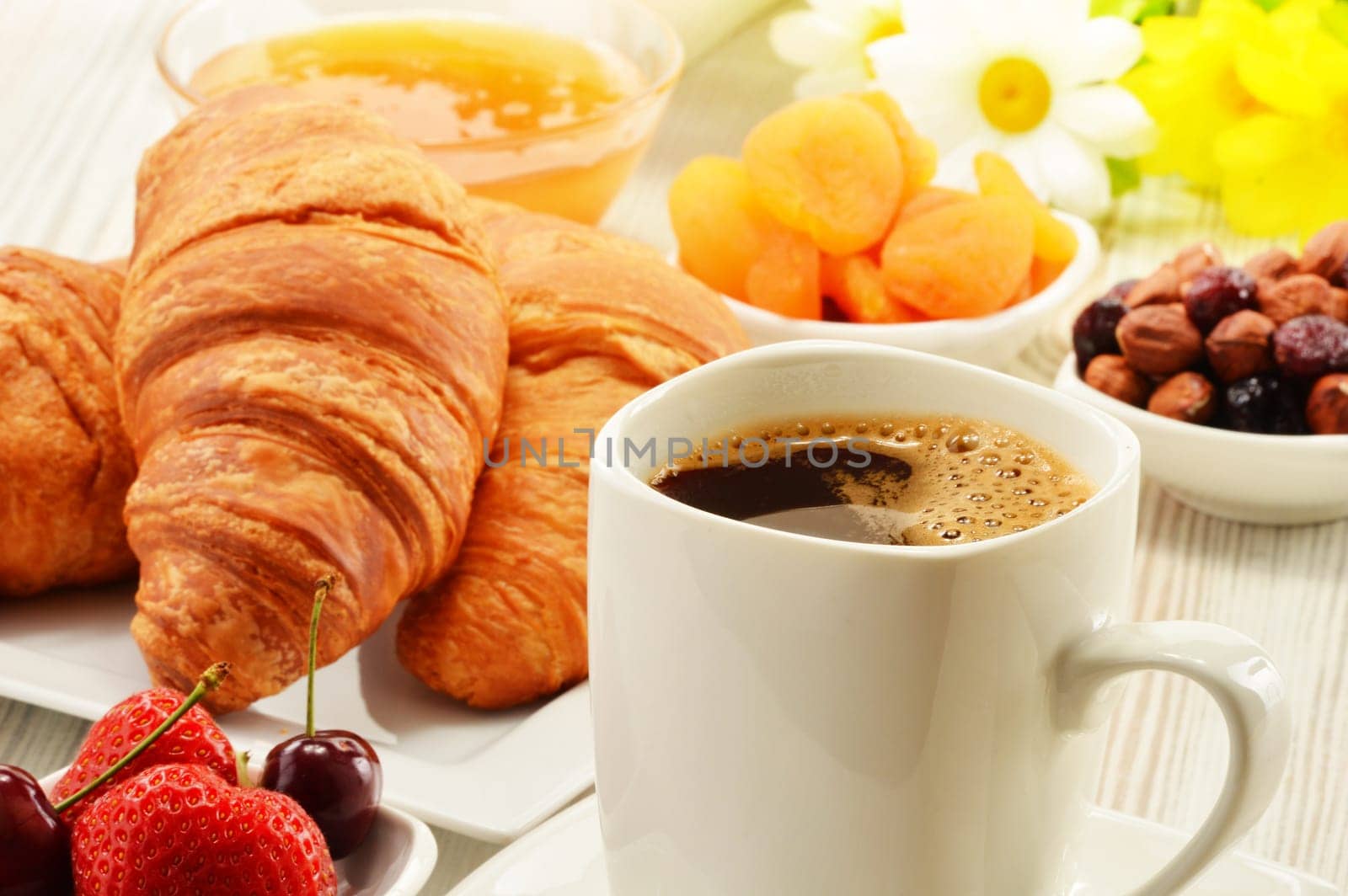 Breakfast with croissants, cup of coffee and fruits