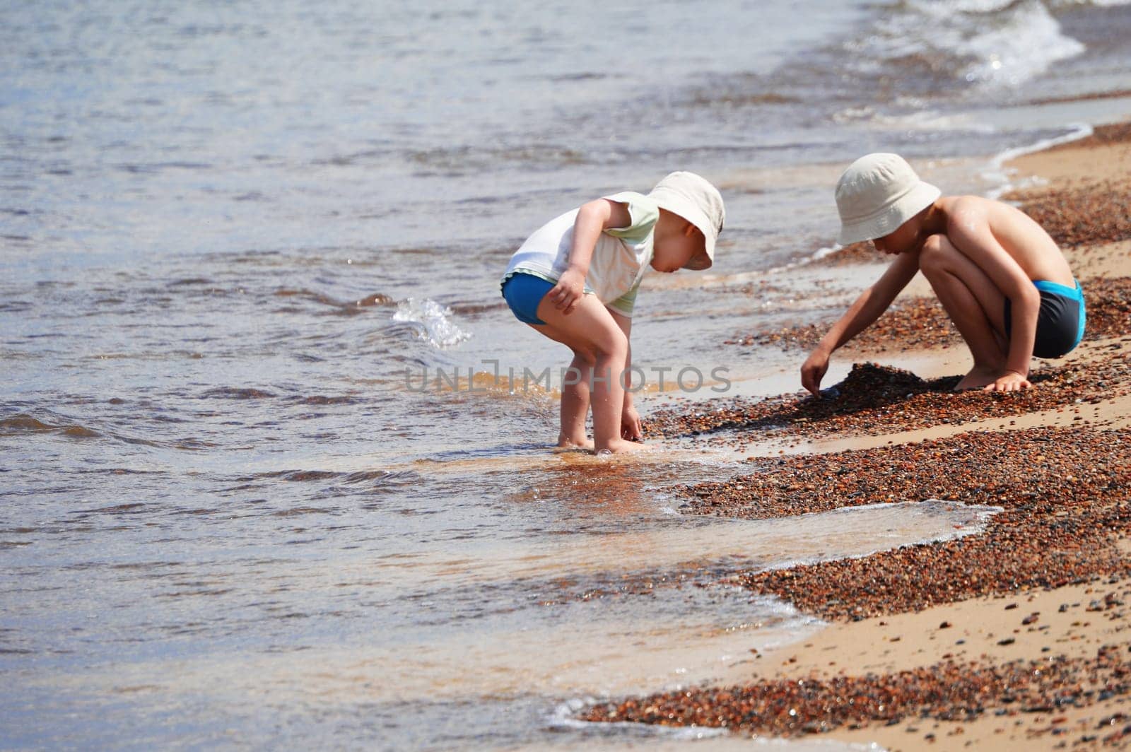 Two little boys playing on the sand beach