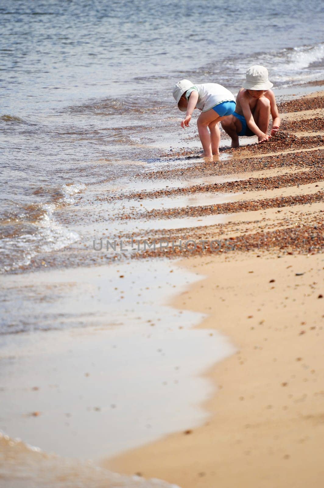 Two little boys playing on the sand beach