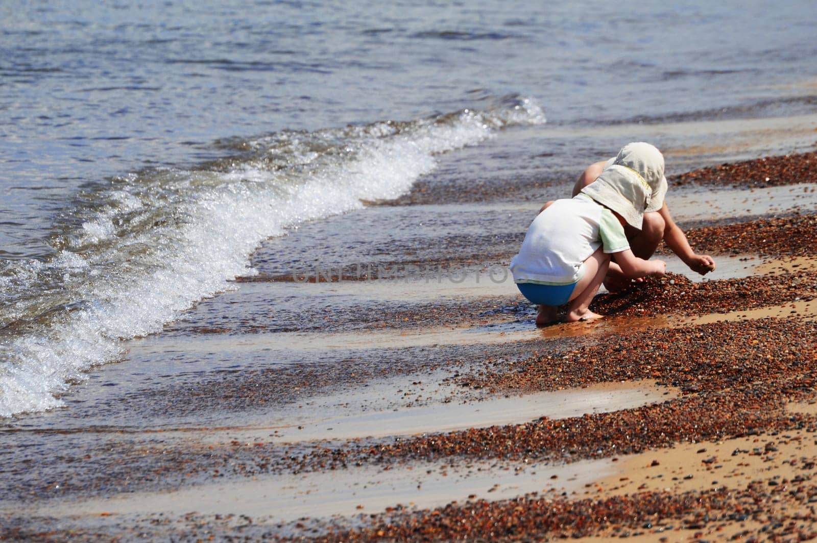Two little boys playing on the sand beach