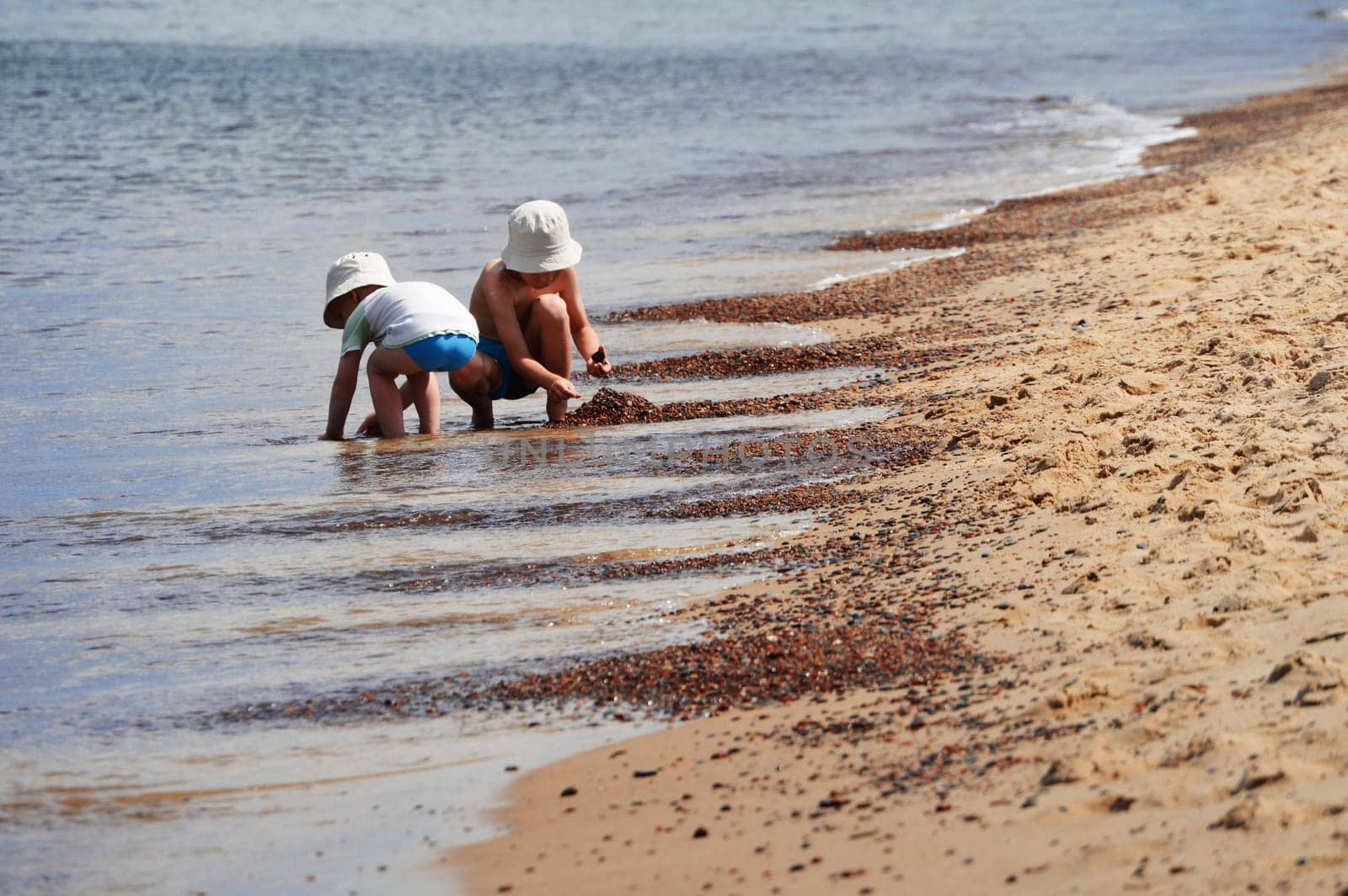 Two little boys playing on the sand beach