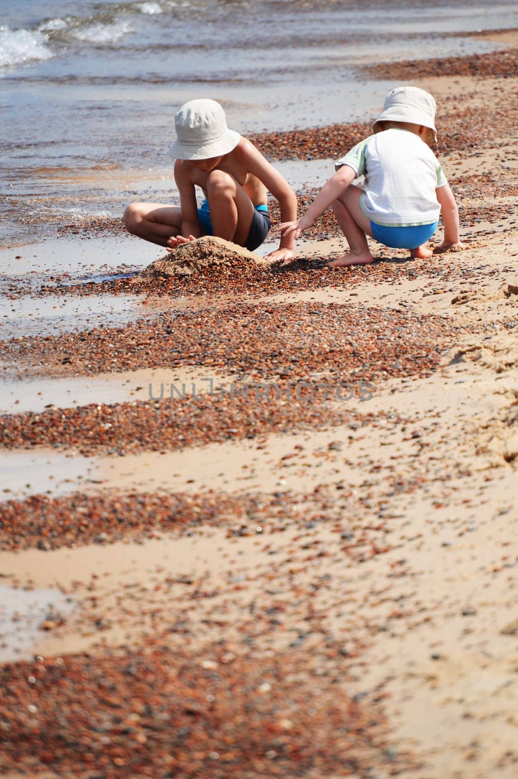 Two little boys playing on the sand beach