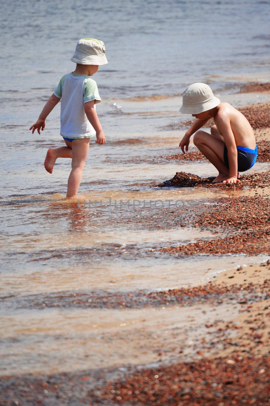 Two little boys playing on the sand beach