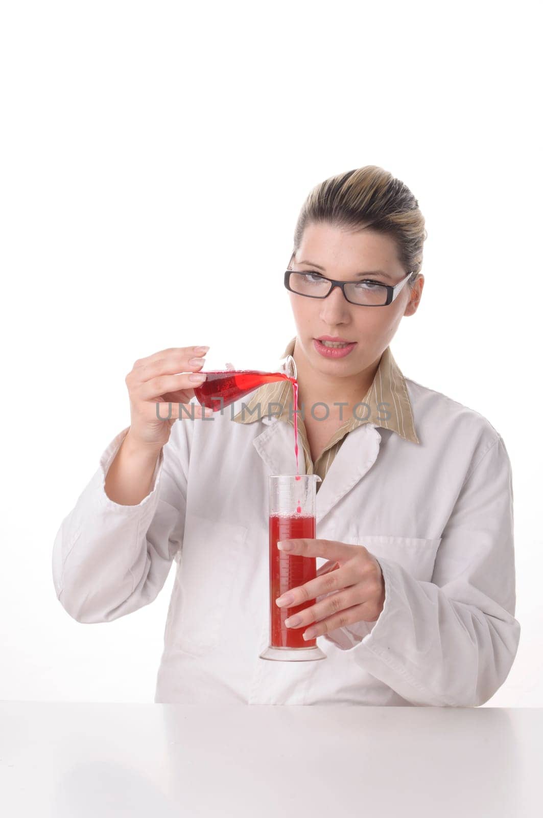 attractive young chemical laboratory assistant with blond hair and glasses works with various coloured liquids in test tubes,exposed against a white background