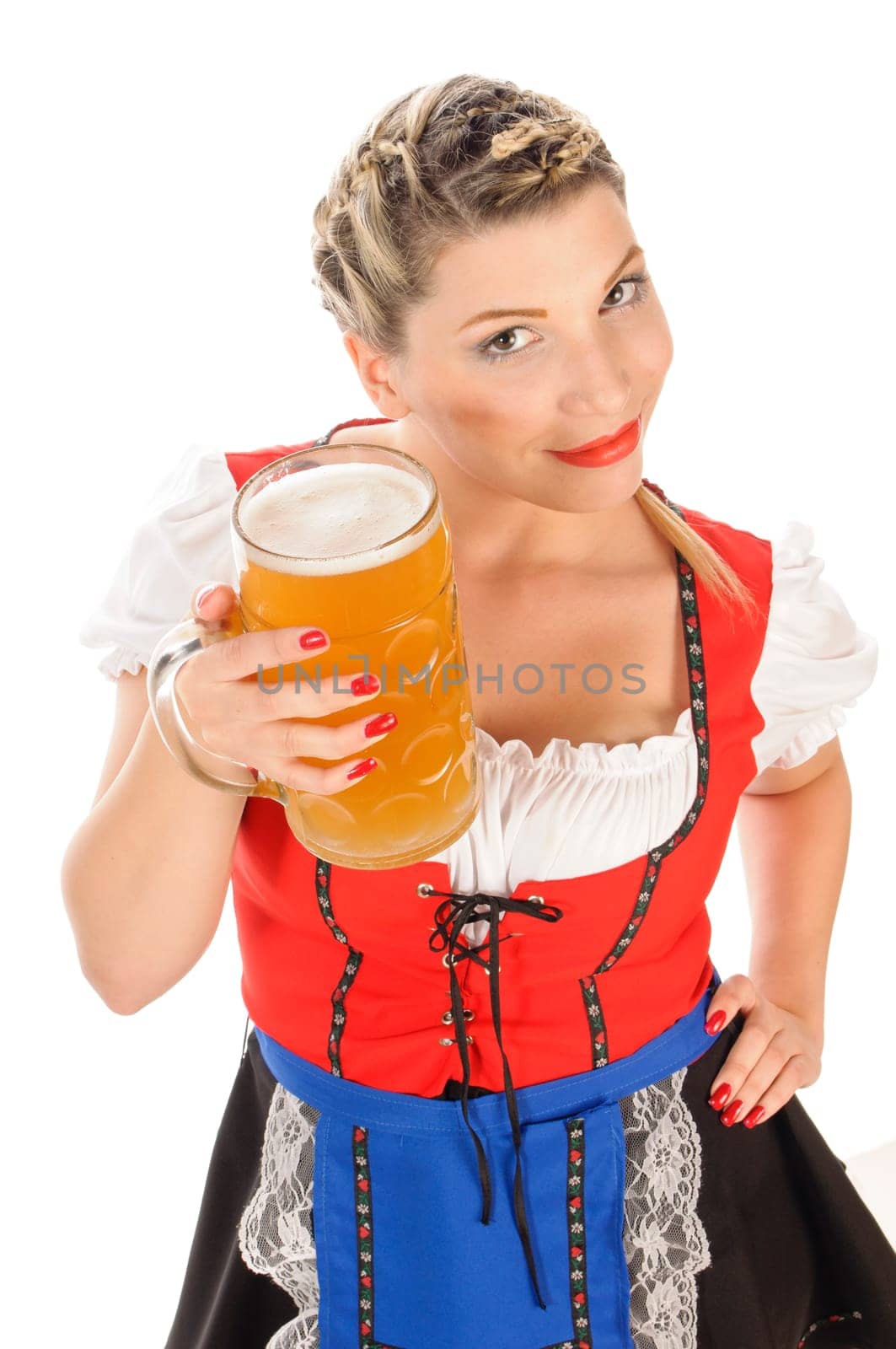 Young attractive woman with blond hair and braids wears a colorful dirdl dress and holds a mug of freshly tapped beer in her hand,exposed against a white background.