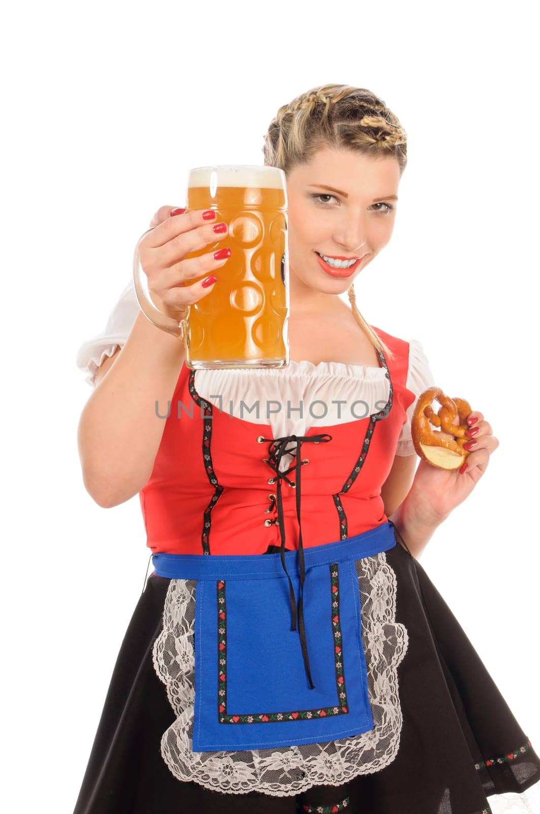 Young attractive woman with blond hair and braids wears a colorful dirdl dress and holds a pretzel and a beer mug with freshly tapped beer in her hand,exposed against a white background.