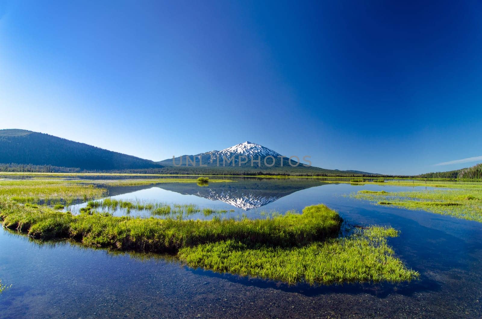A wide angle view of Mount Bachelor being perfectly reflected in a lake near Bend, Oregon