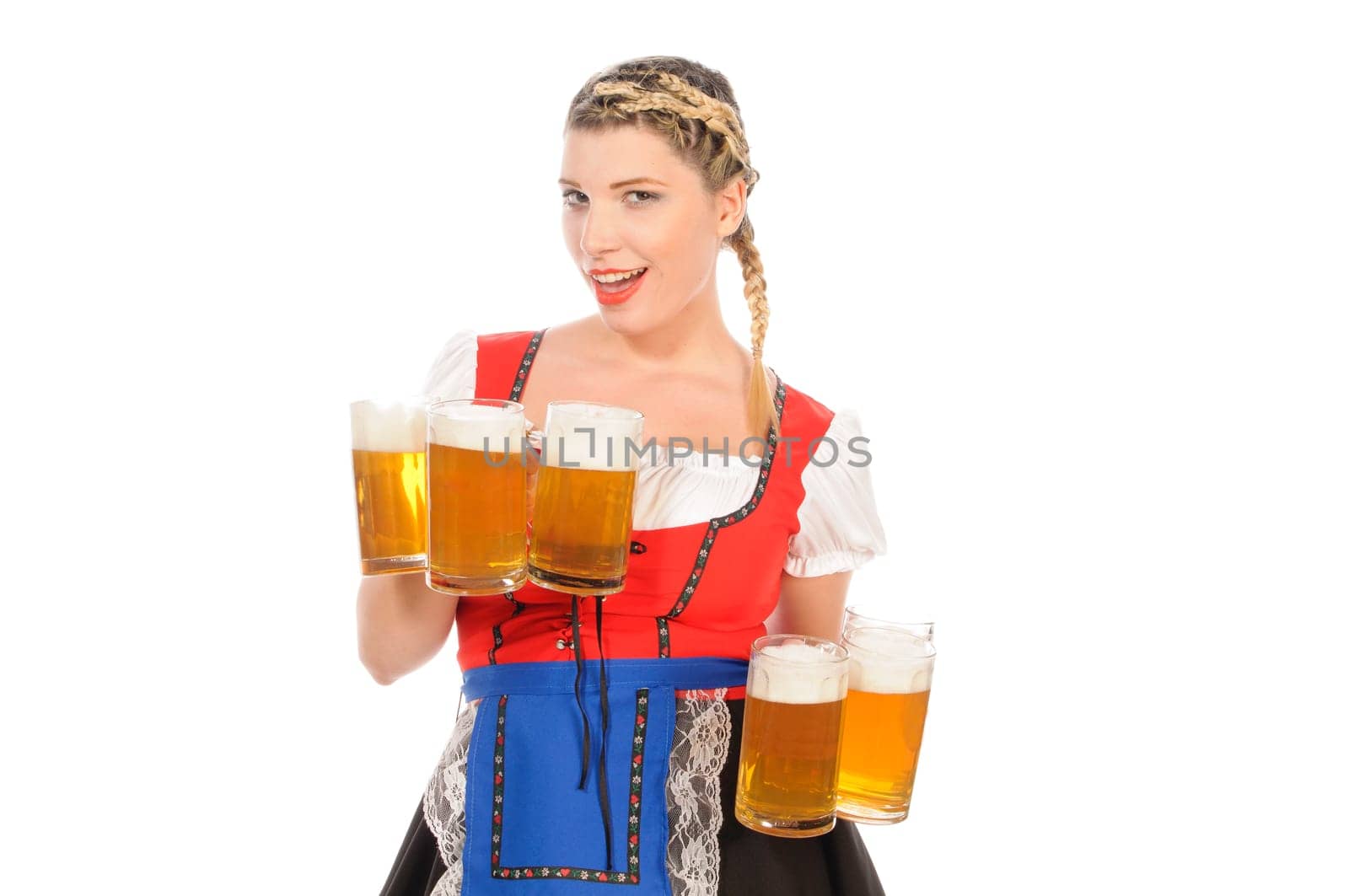 Young attractive woman with blond hair and braids wears a colorful dirdl dress and holds several full beer mugs with freshly tapped beer in her hand,exposed against a white background.