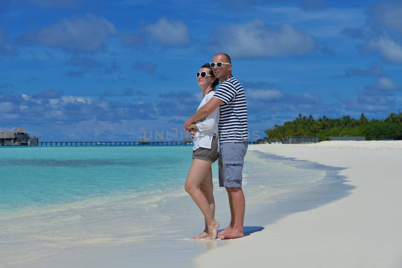 happy young couple have fun and relax at summer vacation on background maldives travel location and beautiful white sand beach