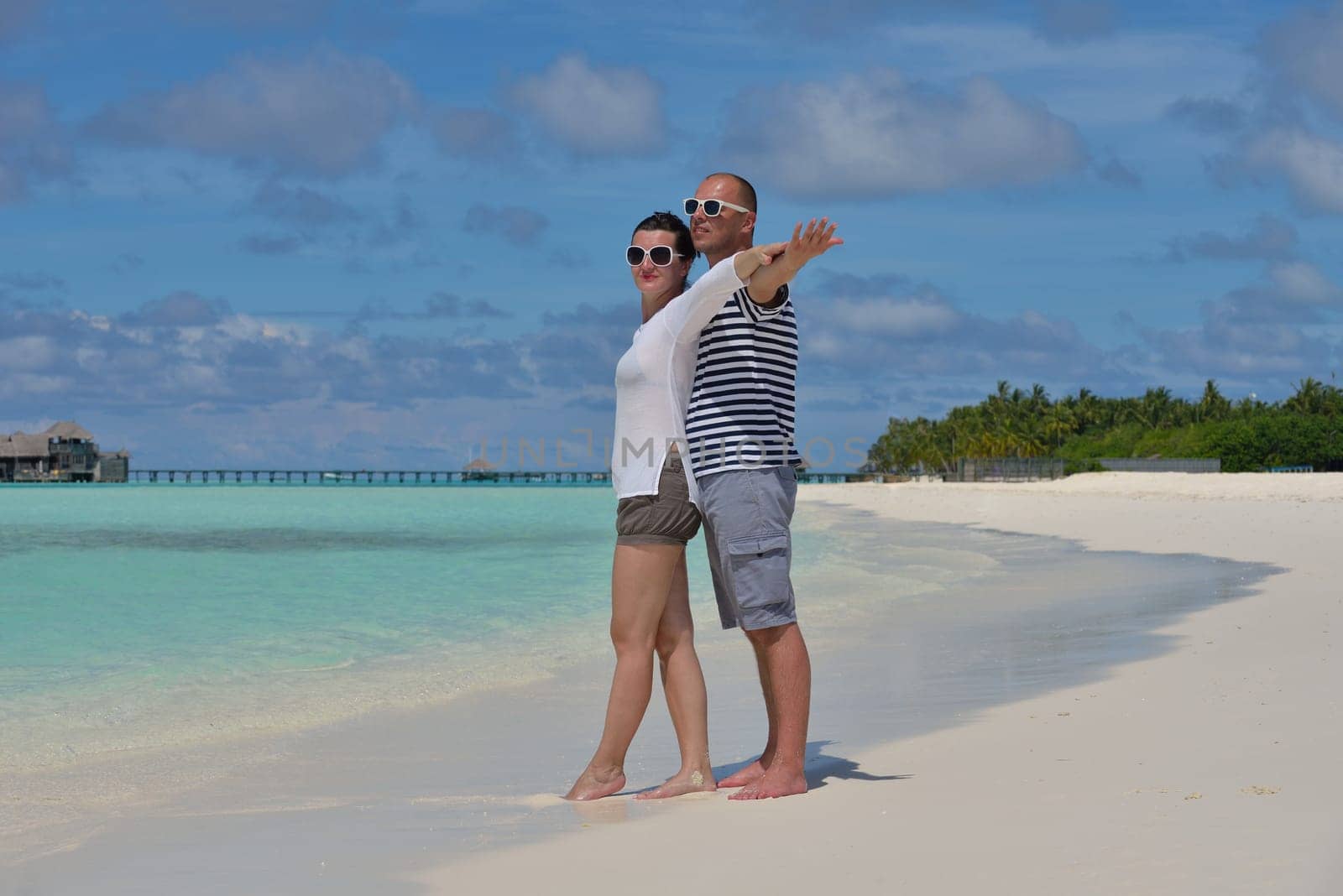happy young couple have fun and relax at summer vacation on background maldives travel location and beautiful white sand beach