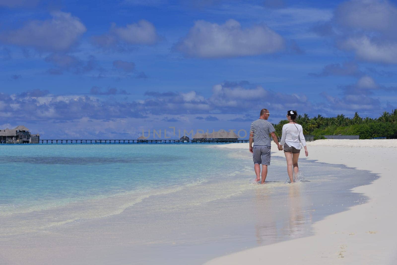 happy young couple have fun and relax at summer vacation on background maldives travel location and beautiful white sand beach