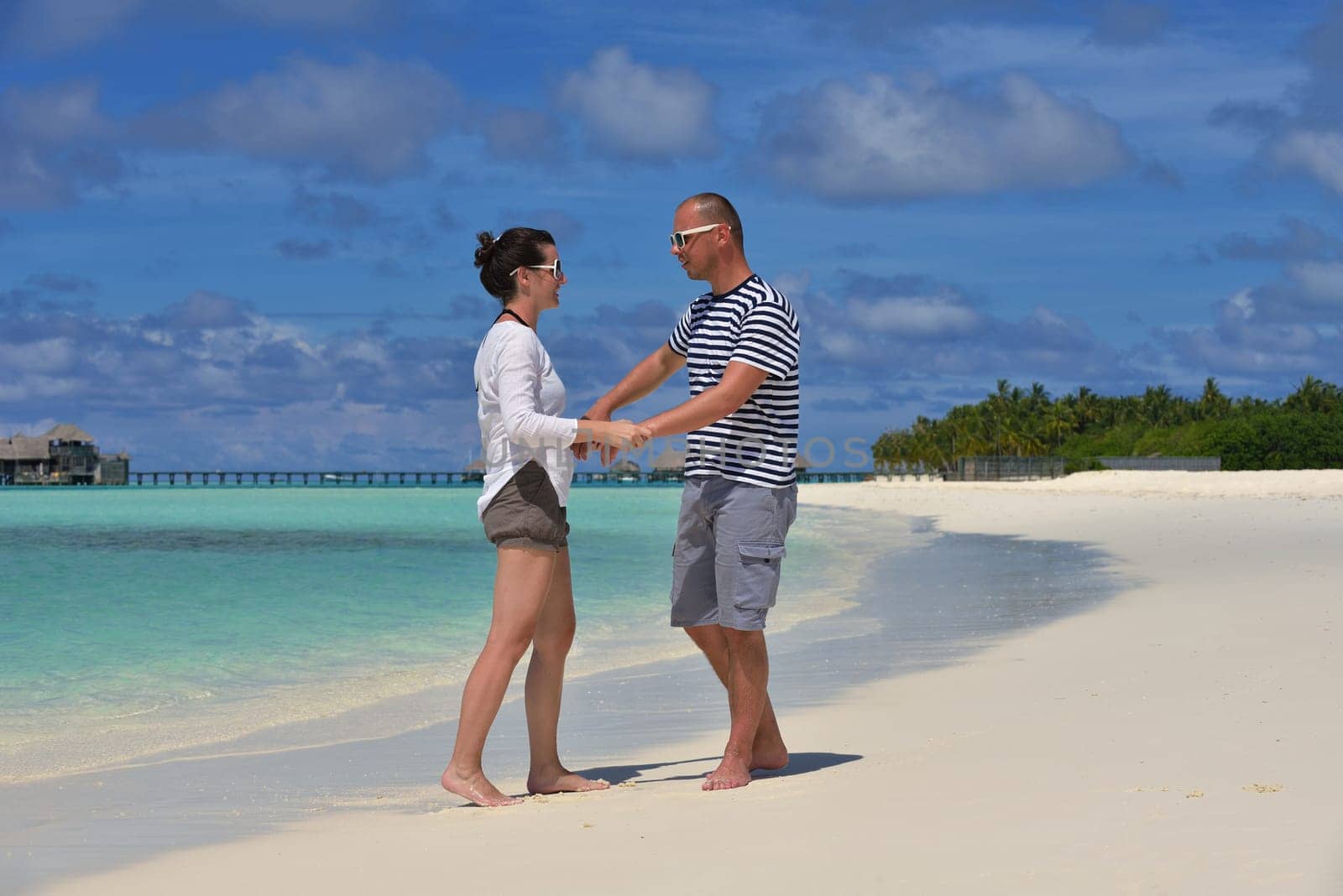 happy young couple have fun and relax at summer vacation on background maldives travel location and beautiful white sand beach