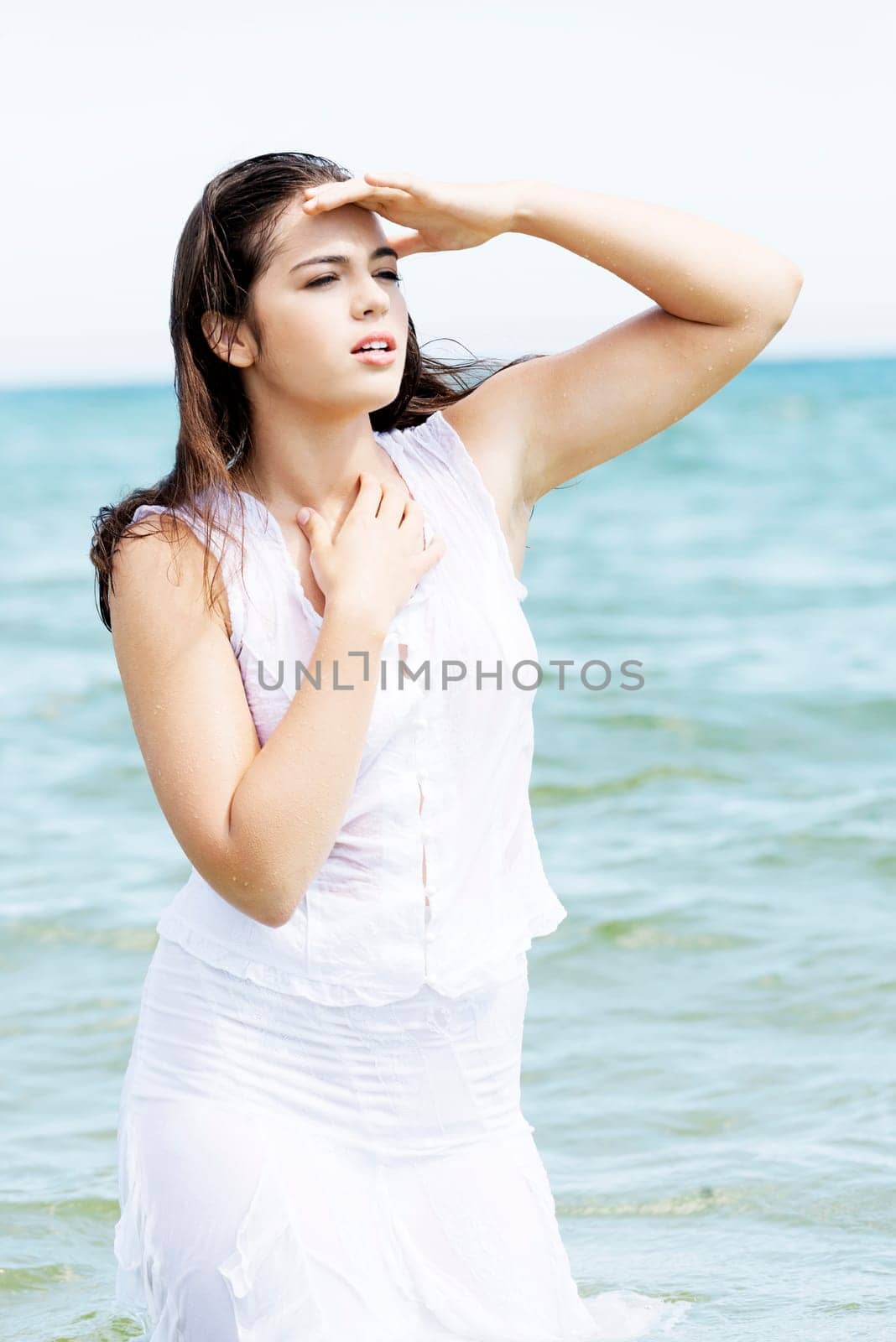 summer woman on the beach looking far away.
