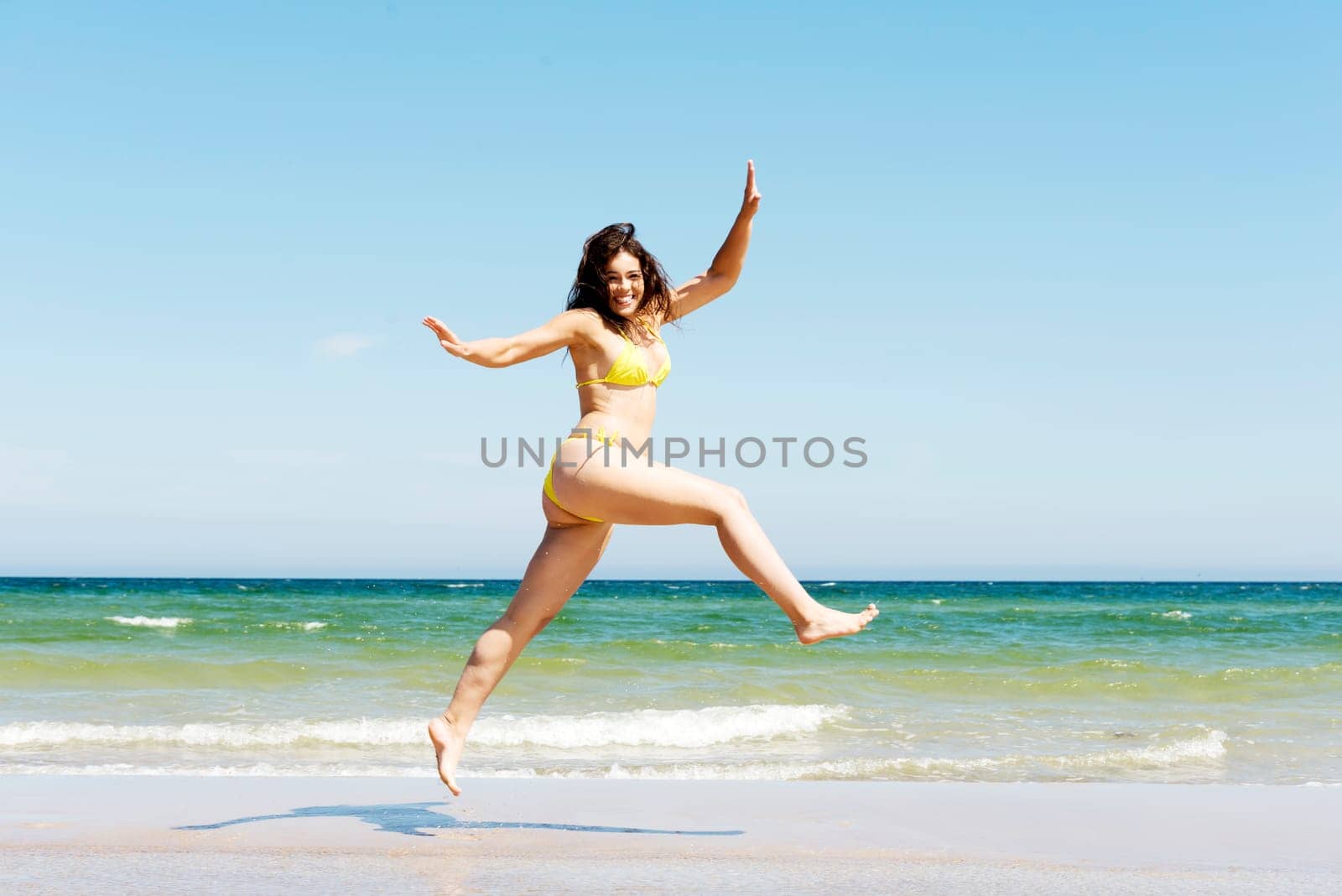 happy free girl jumping on the beach