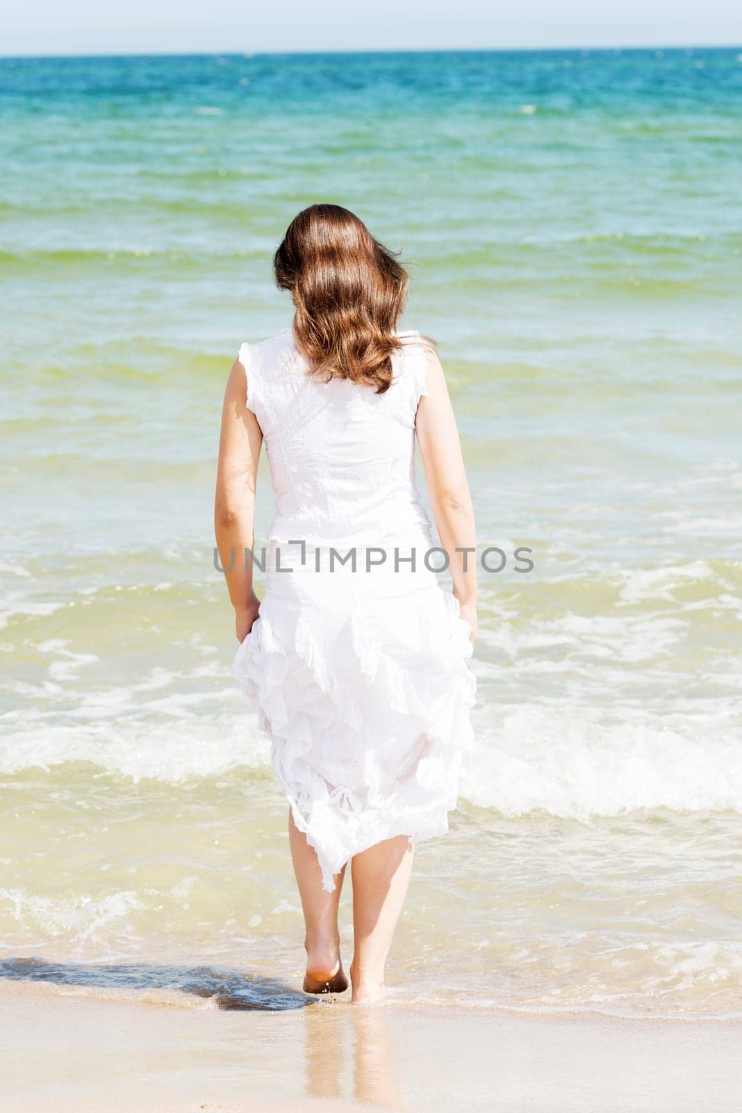 summer happy woman on the beach,wearing a white dress.