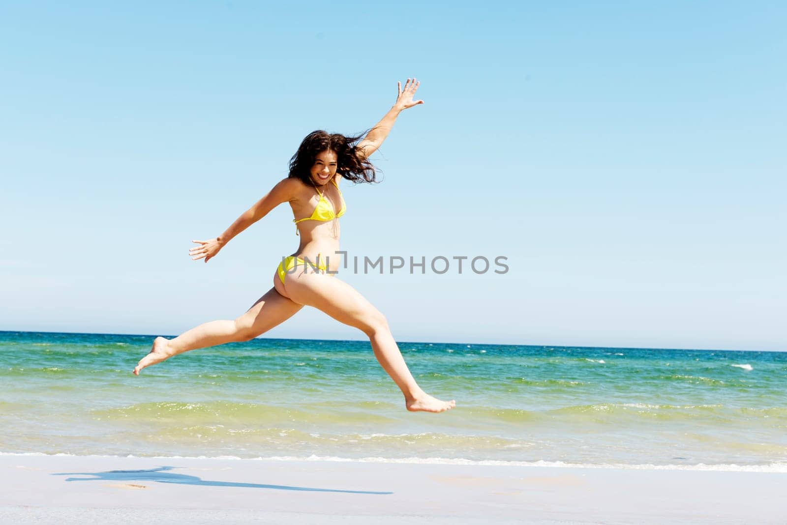 happy free girl jumping on the beach